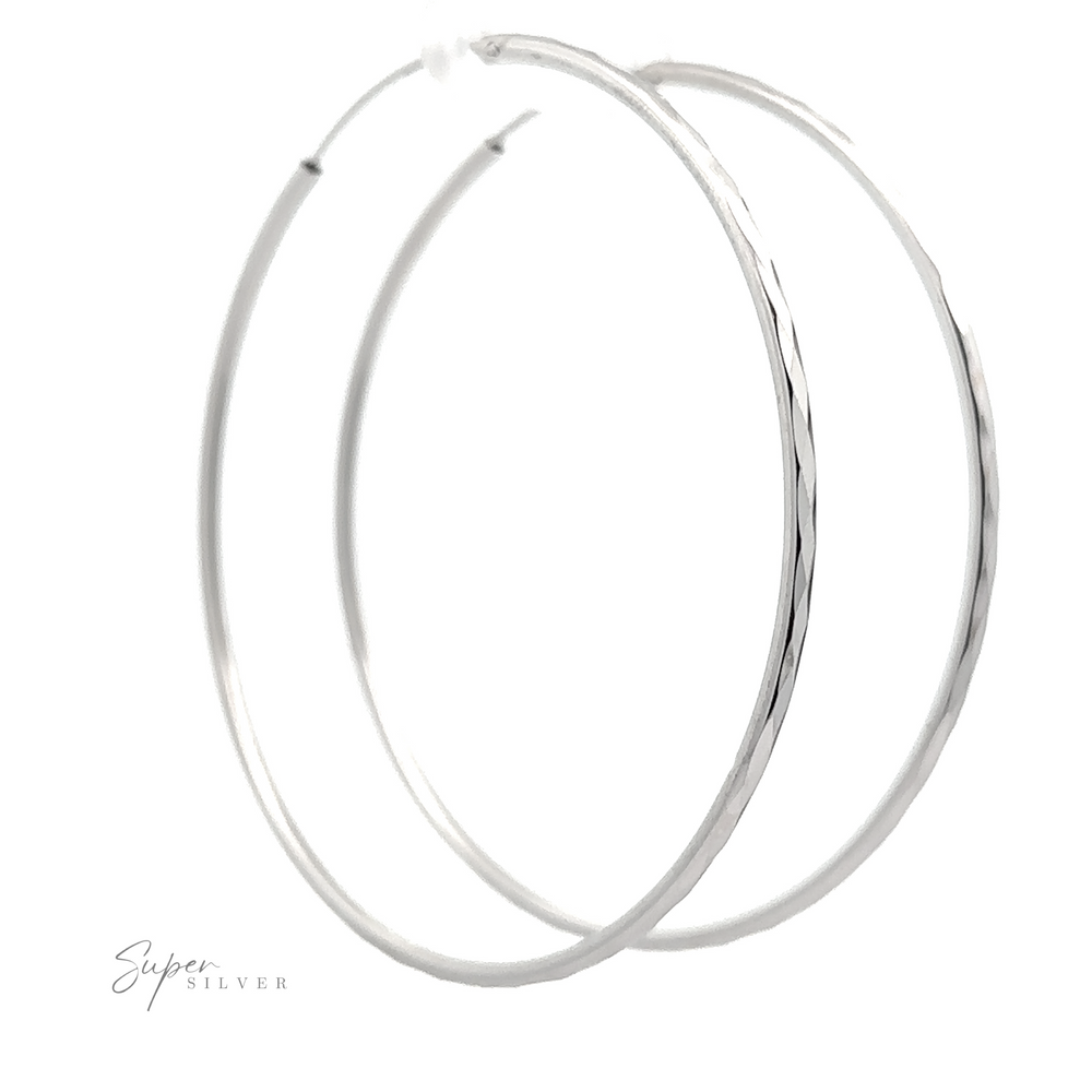 
                  
                    2mm Diamond Faceted Hoops with a diamond-cut finish on a white background, signed "super silver".
                  
                