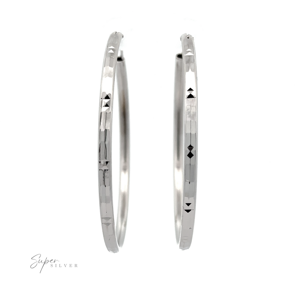 
                  
                    A pair of Modern 3mm Rhodium Finish Facet Hoops with geometric cut-out patterns, displayed against a white background with "super silver" written in cursive at the bottom.
                  
                