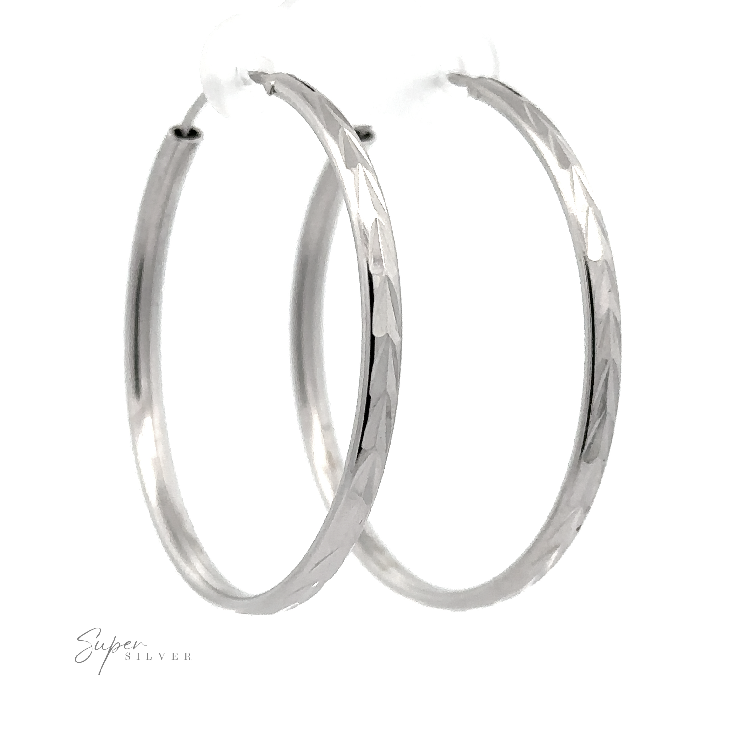 A pair of 3mm Chevron Faceted Hoops with a faceted design, isolated on a white background, with a signature in the corner that reads "super silver.