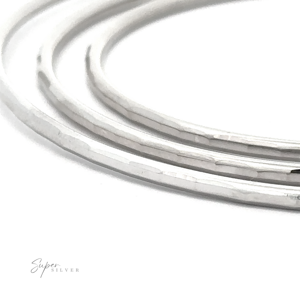 Close-up of four 2mm Diamond Cut Hoop Earrings with a rhodium finish, displayed on a white surface with the text 