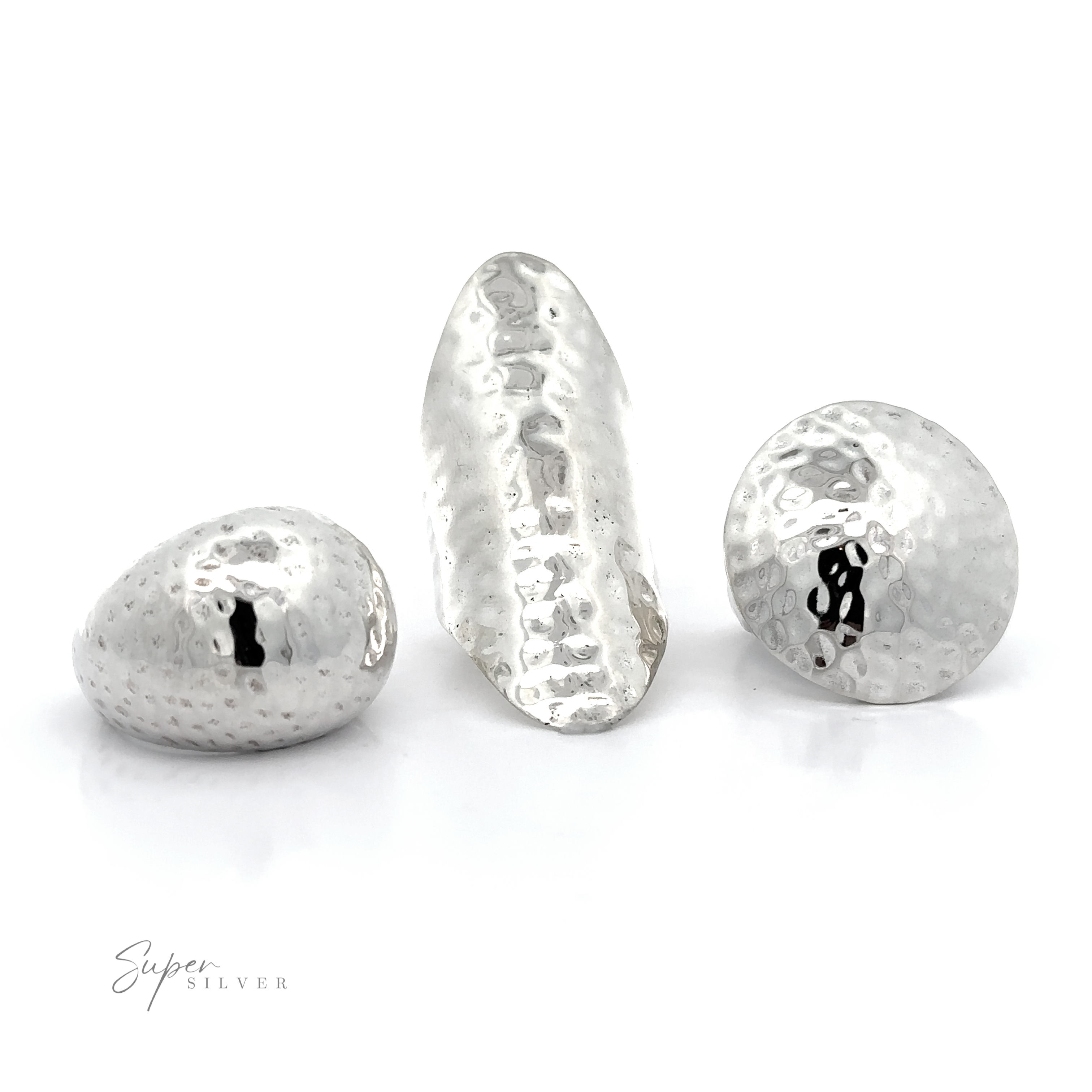 Three silver hammered beads on a white background, showcasing the boldness of the Statement Hammered Rings collection.