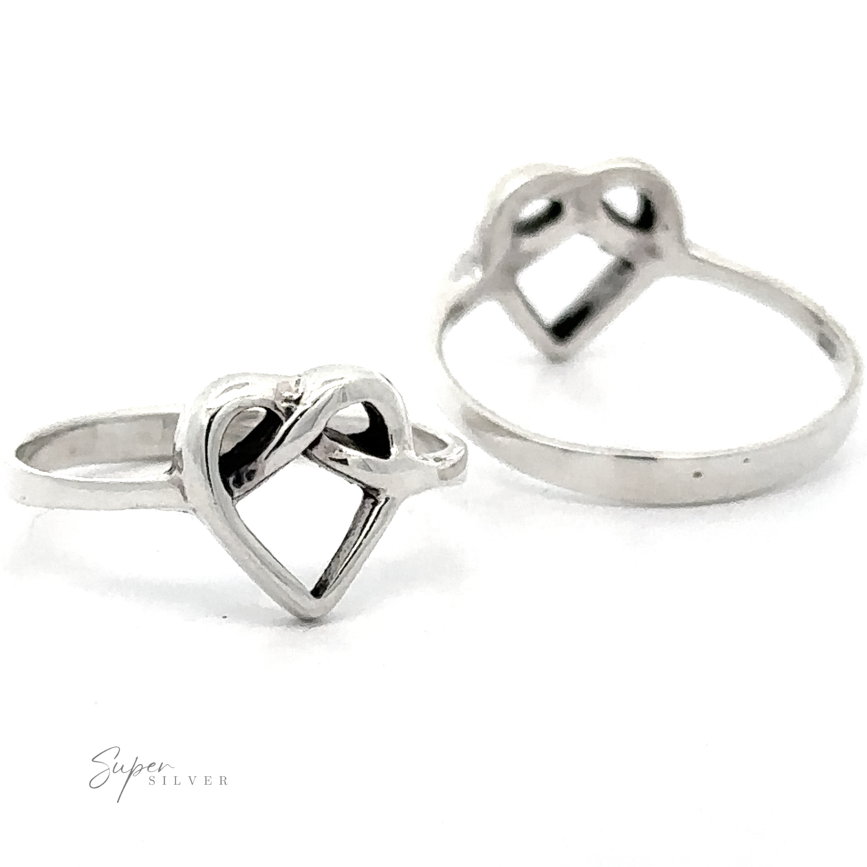 Two Entwined Heart Knot Rings on a white background, one ring in focus with overlapping hearts design and another slightly blurred in the background.