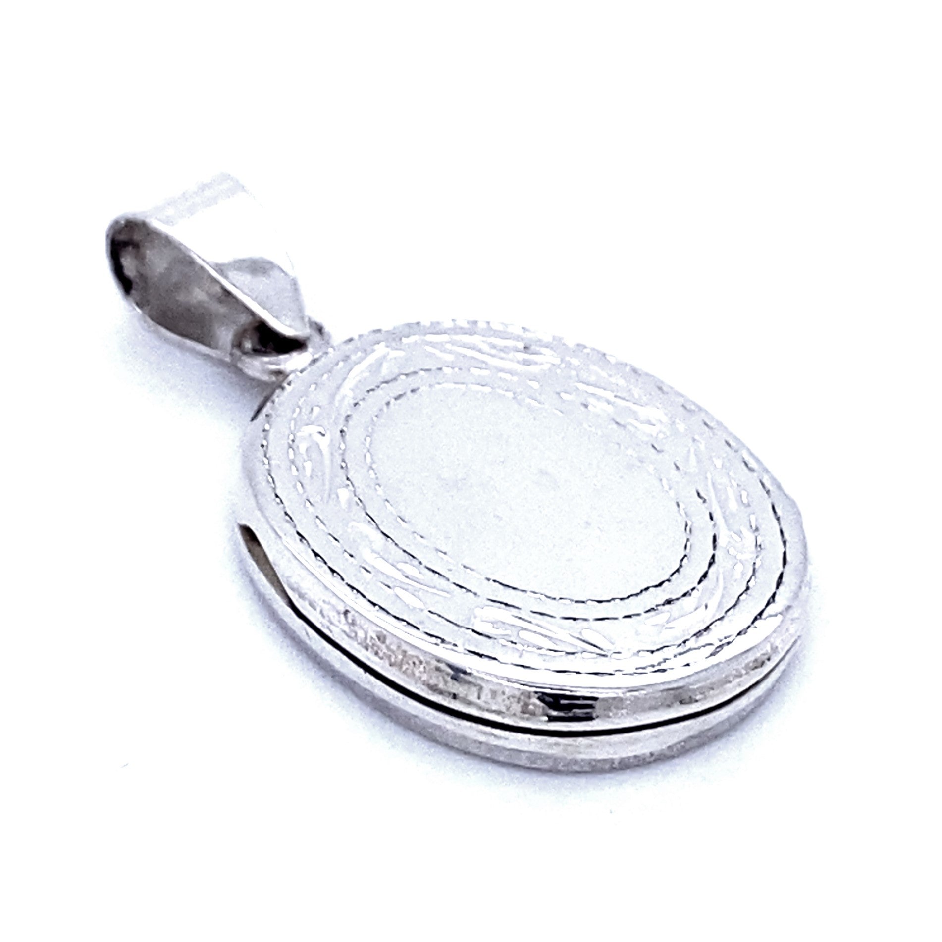 An Oval Locket with Etched Border, featuring a simple bail for attaching to a chain, exudes the timeless charm of Victorian era jewelry.