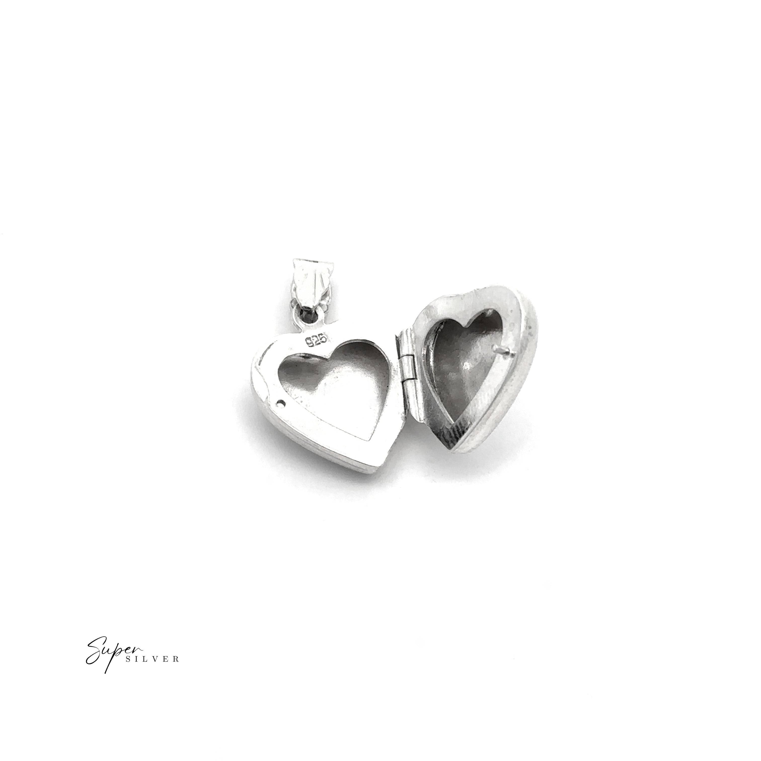 The Tiny Heart-Shaped Locket with filigree etching in sterling silver is shown open on a white background, revealing two empty compartments.