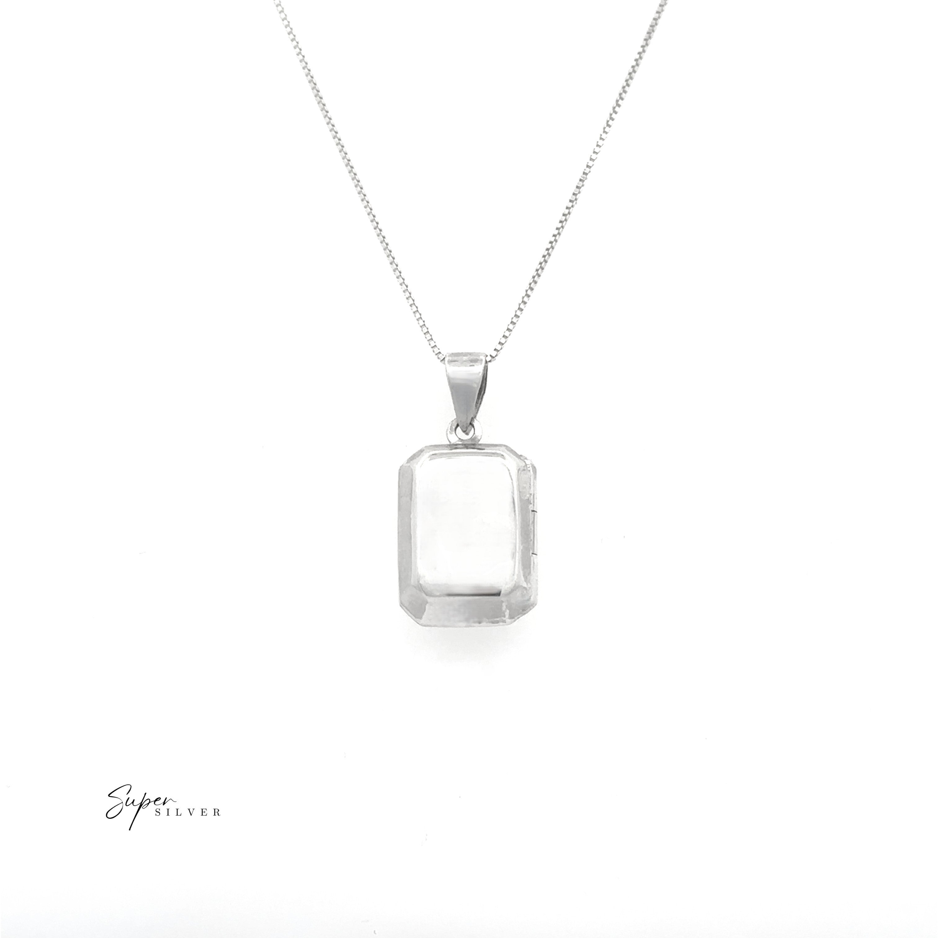 The Beveled Edge Rectangular Locket, a minimalist silver necklace with a clear gemstone pendant, is displayed on a white background for an elegant touch.