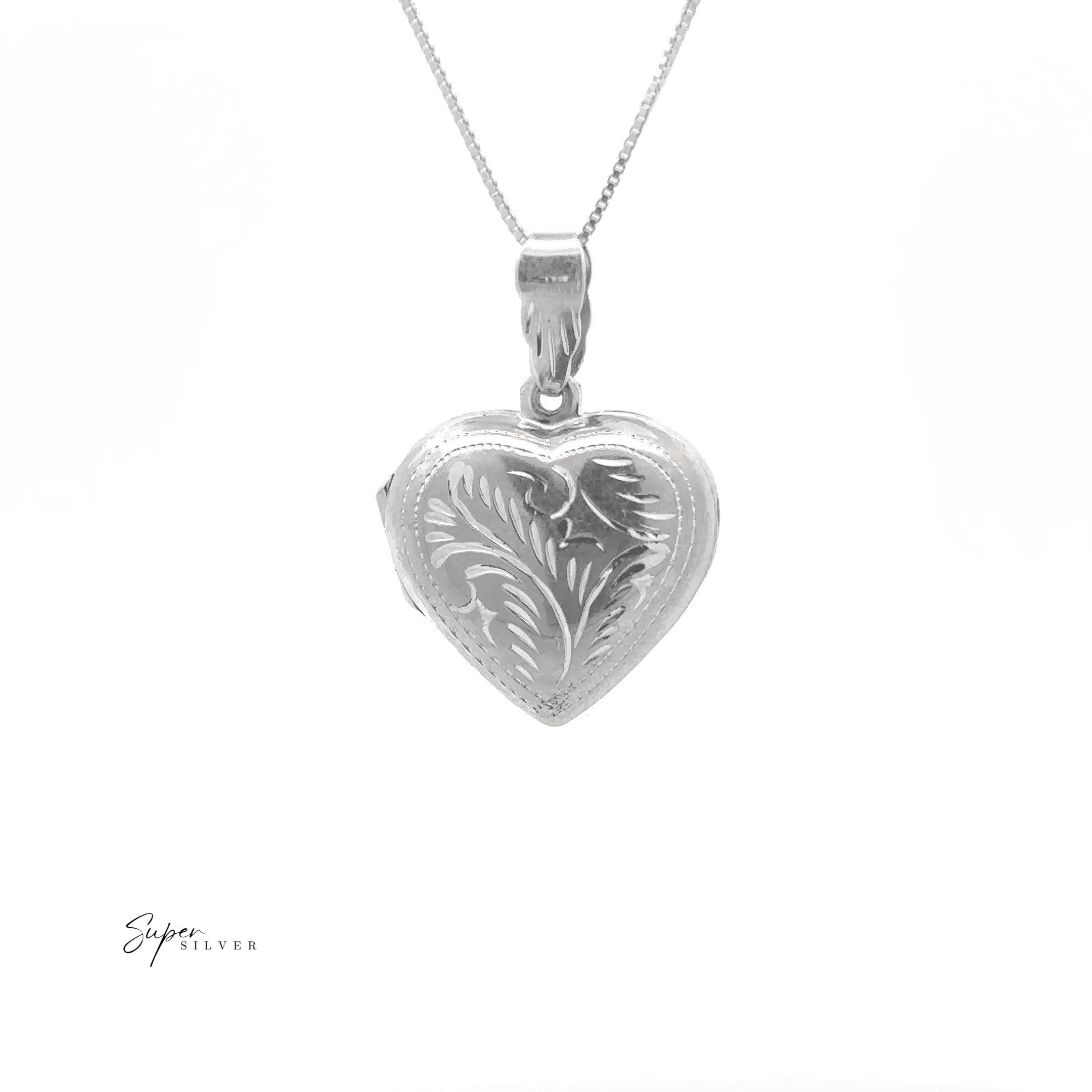 The Timeless Heart Locket, crafted from sterling silver with an engraved leaf pattern and vintage charm, hangs from a fine chain against a white background.