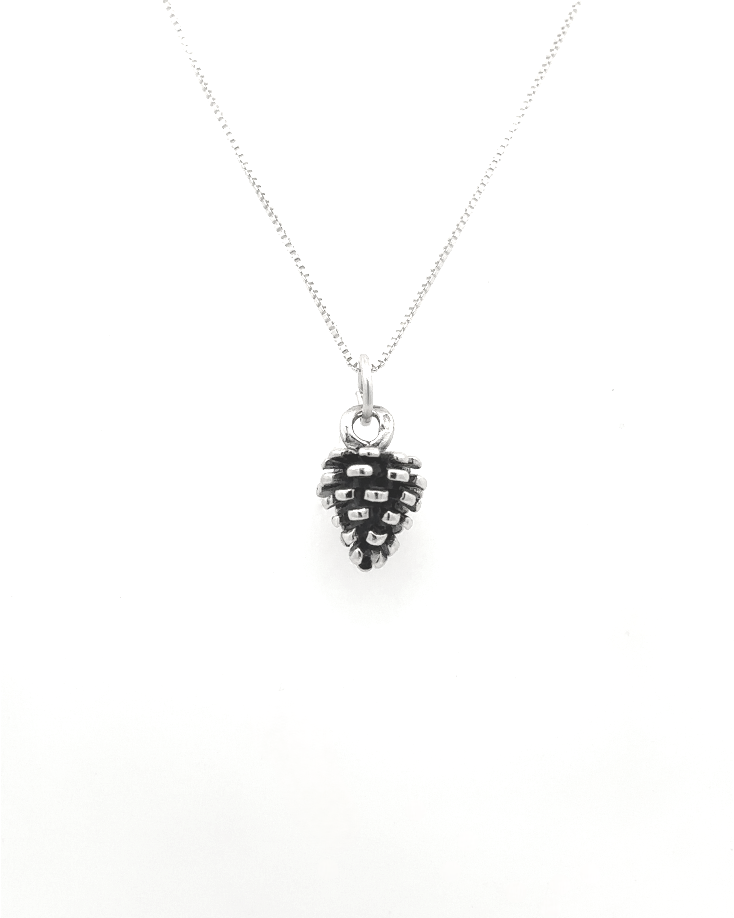 The Pinecone Pendant, a sterling silver necklace adorned with a delicate pinecone charm, is ideal for nature enthusiasts and is showcased beautifully against a white background.