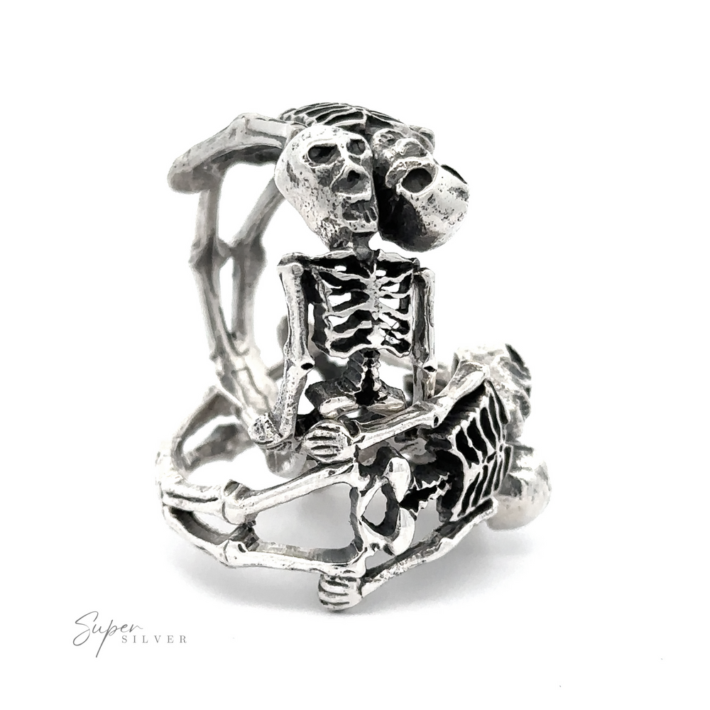 Sterling Silver Skeleton Ring featuring a detailed skeleton design in a seated position with its head resting on one hand, set against a white background.