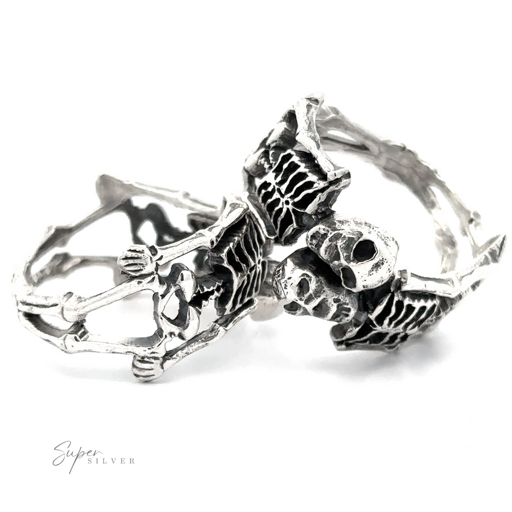 Sterling Silver Skeleton ring shaped like interlocking skeletons, displayed on a white background, highlighting intricate details and craftsmanship.