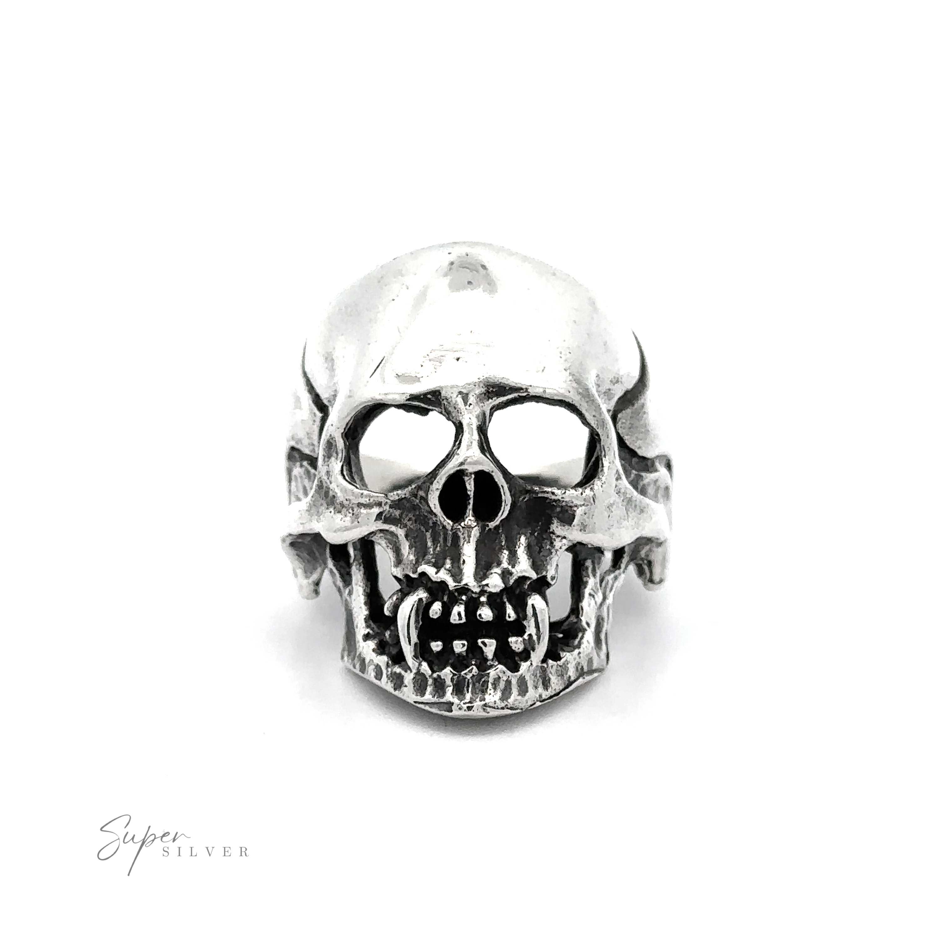 A silver Large Fanged Skull Statement Ring with prominent teeth and hollow eye sockets, embodying a gothic aesthetic. The background is plain white, and the words "Super Silver" are written in the bottom left corner.