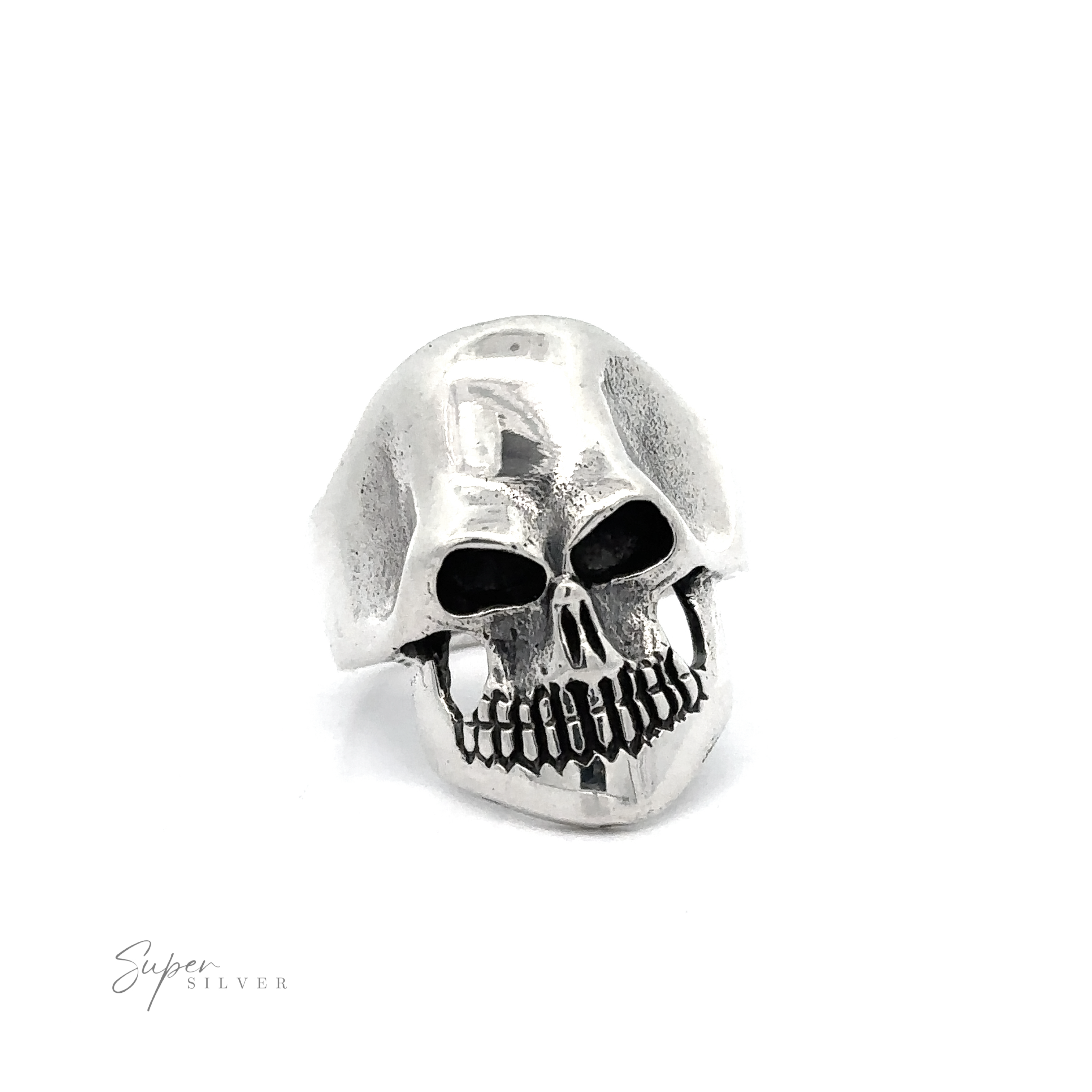 A silver skull-shaped ring with hollow eye sockets and detailed teeth design, exuding edgy elegance, displayed against a plain white background. The Silver Skull Statement Ring features the brand name "Super Silver" in the bottom left corner.