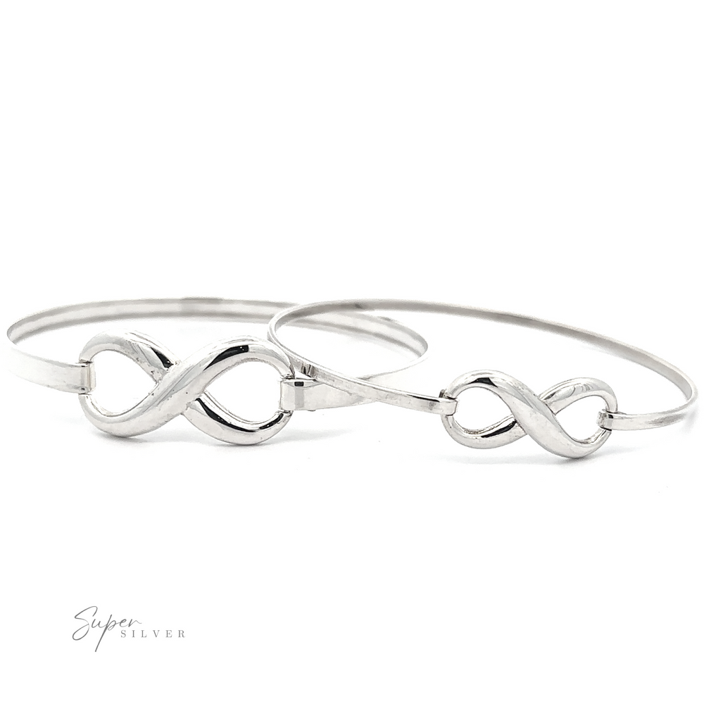 
                  
                    Two Infinity Bracelets are displayed side by side on a white background, each featuring a secure latch clasp, with a subtle "Super Silver" logo in the bottom left corner.
                  
                