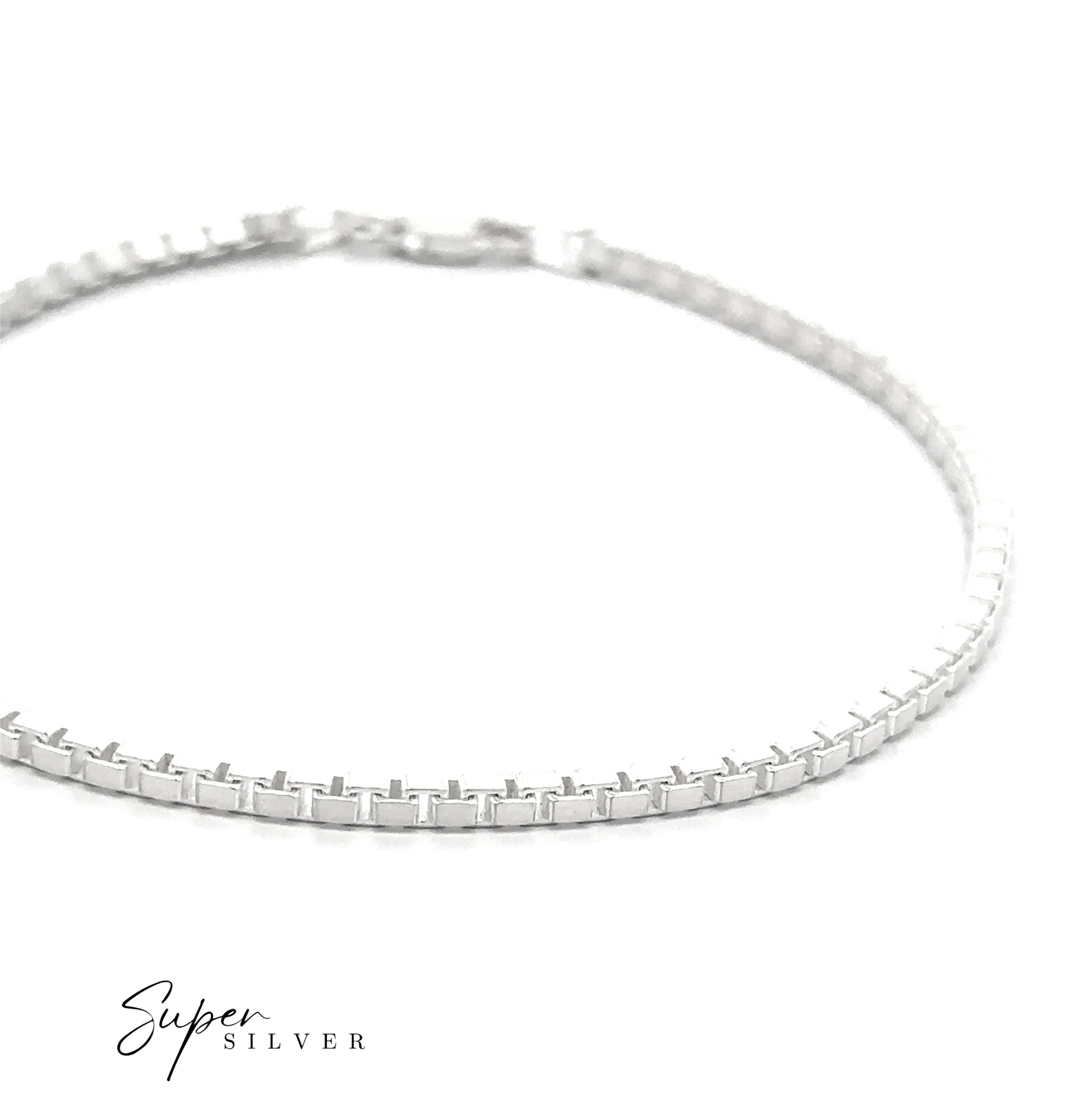 A close-up of a silver tennis bracelet with a box clasp on a white background, styled with the Italian Titan Box Chain. The “Super Silver” logo appears in the bottom left corner.