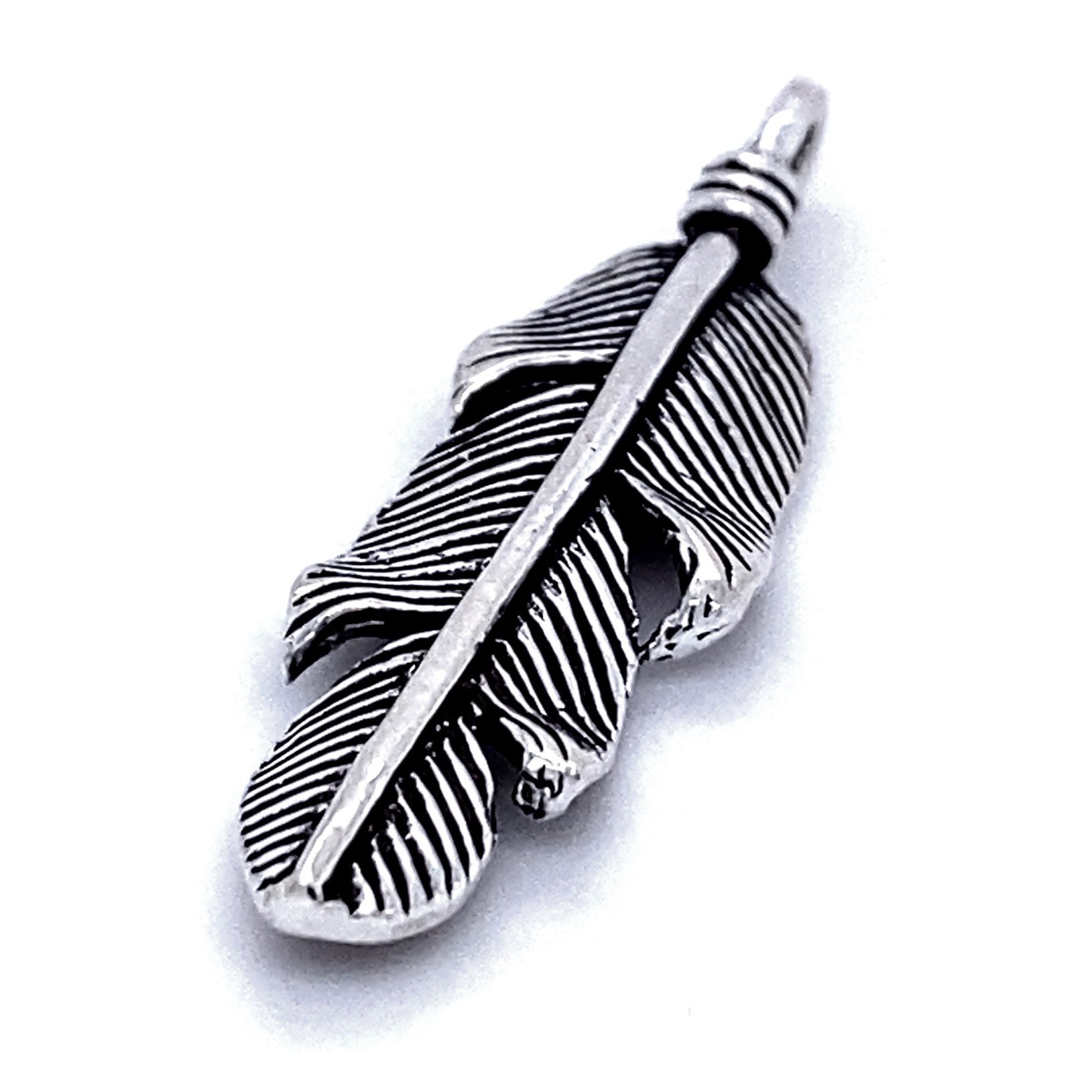 A Rustic Feather Pendant featuring intricate details, including a vertical central shaft and textured feather lines, exemplifies rustic jewelry at its finest.