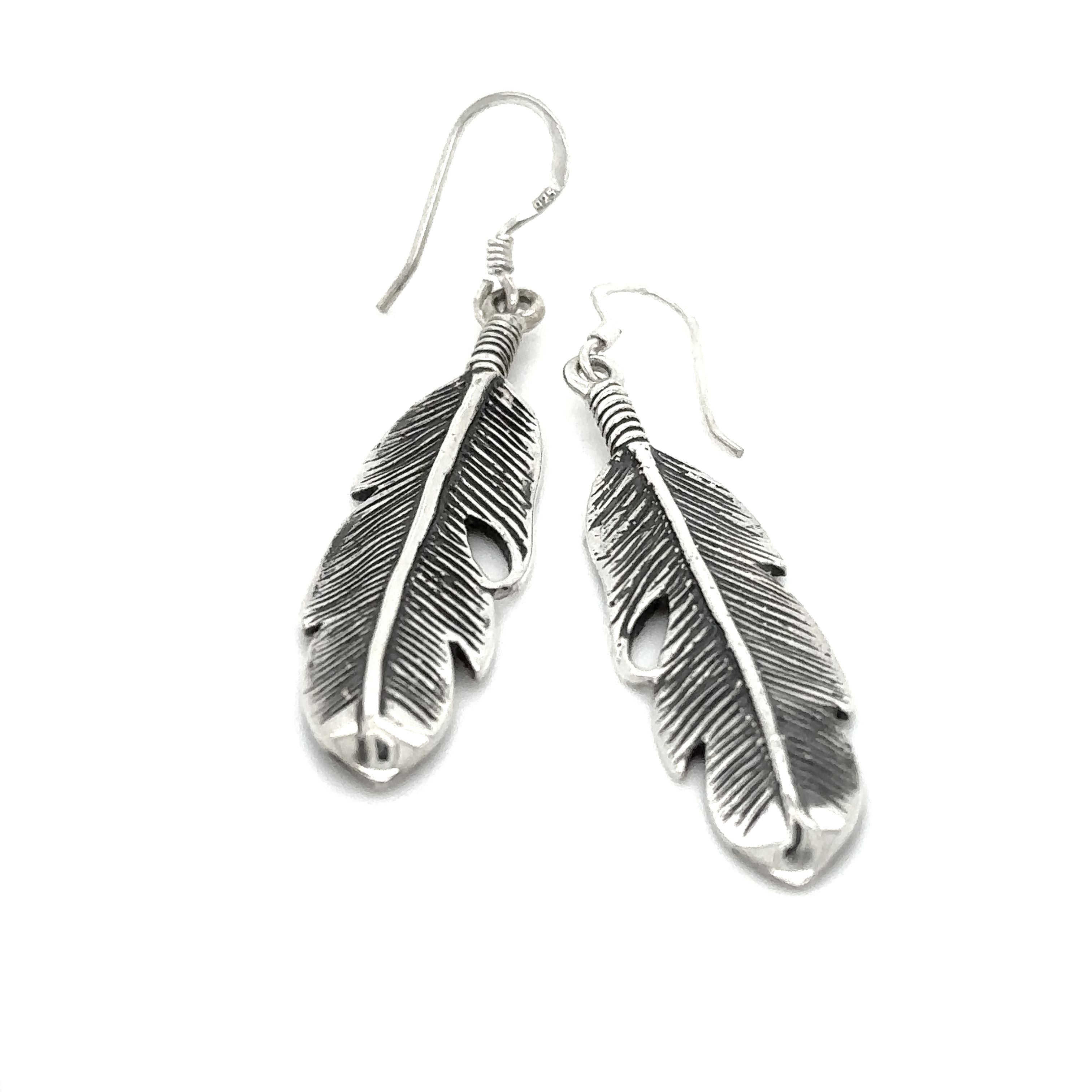A pair of Super Silver Medium Feather Earrings, a timeless gift for loved ones, showcased beautifully on a white background.