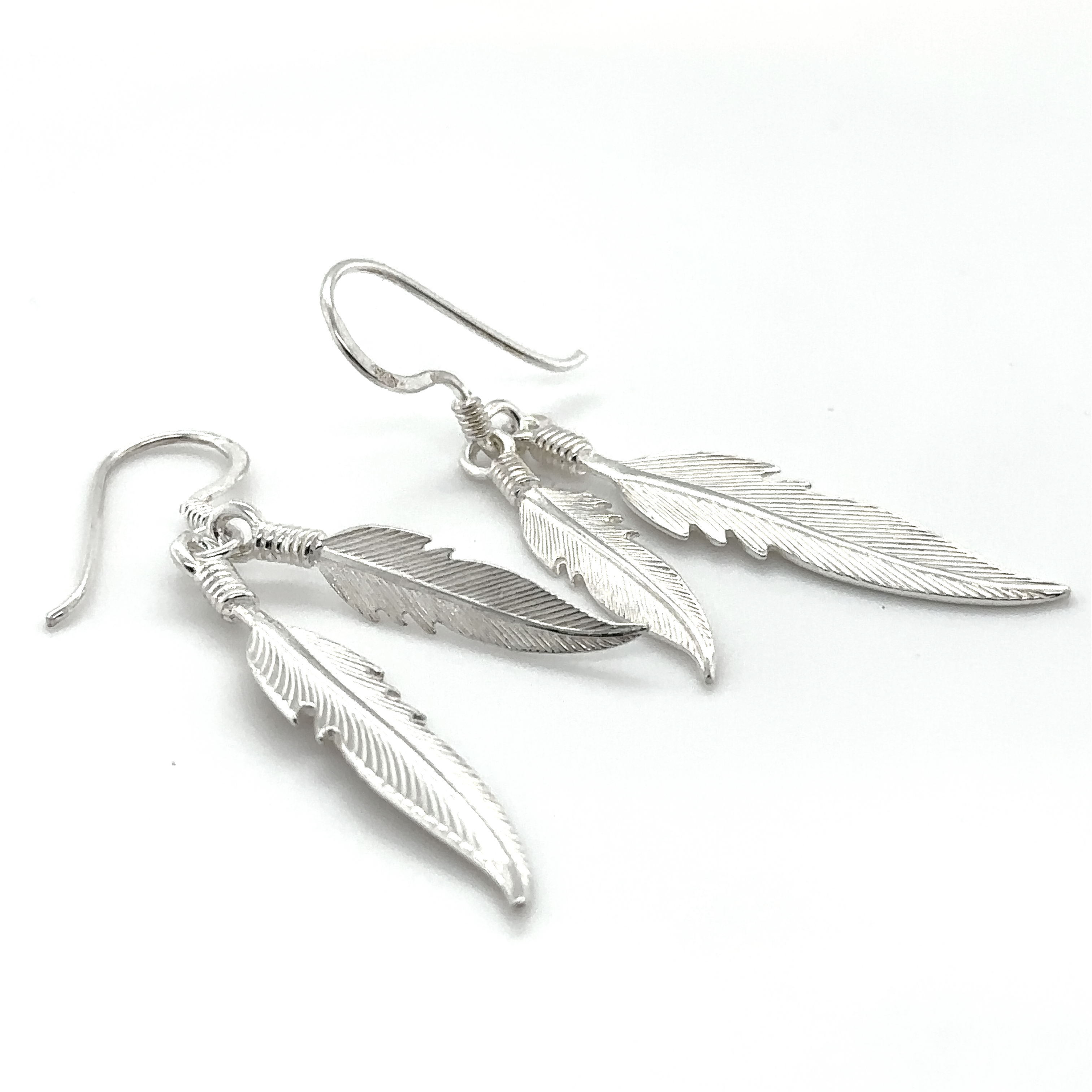 A pair of Super Silver Double Feather Earrings on a white background.