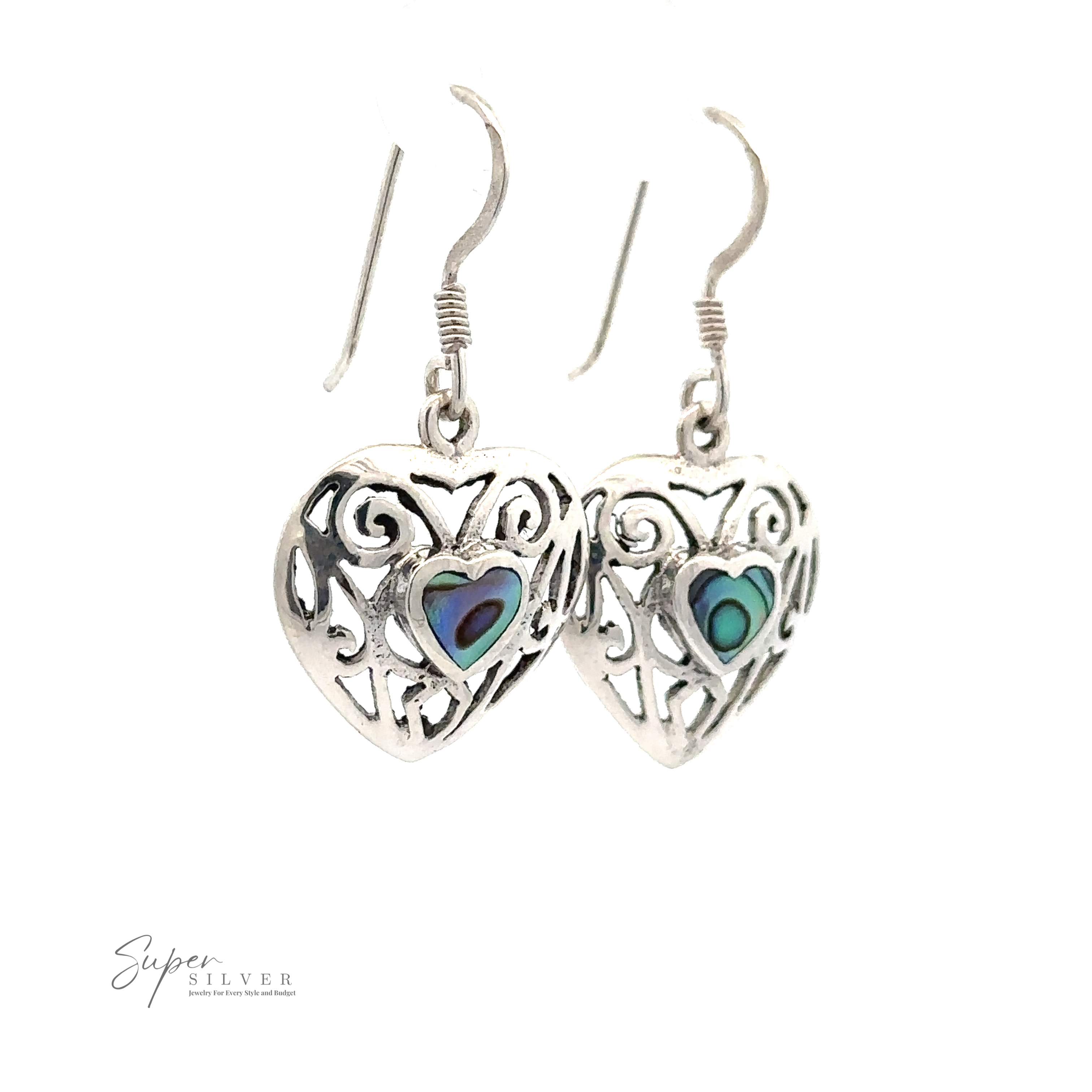 A pair of Elegant Heart Shaped Abalone Earrings with intricate cut-out designs and colorful inlays hang from hooks against a white background. "Super Silver" branding is visible in the bottom left corner.