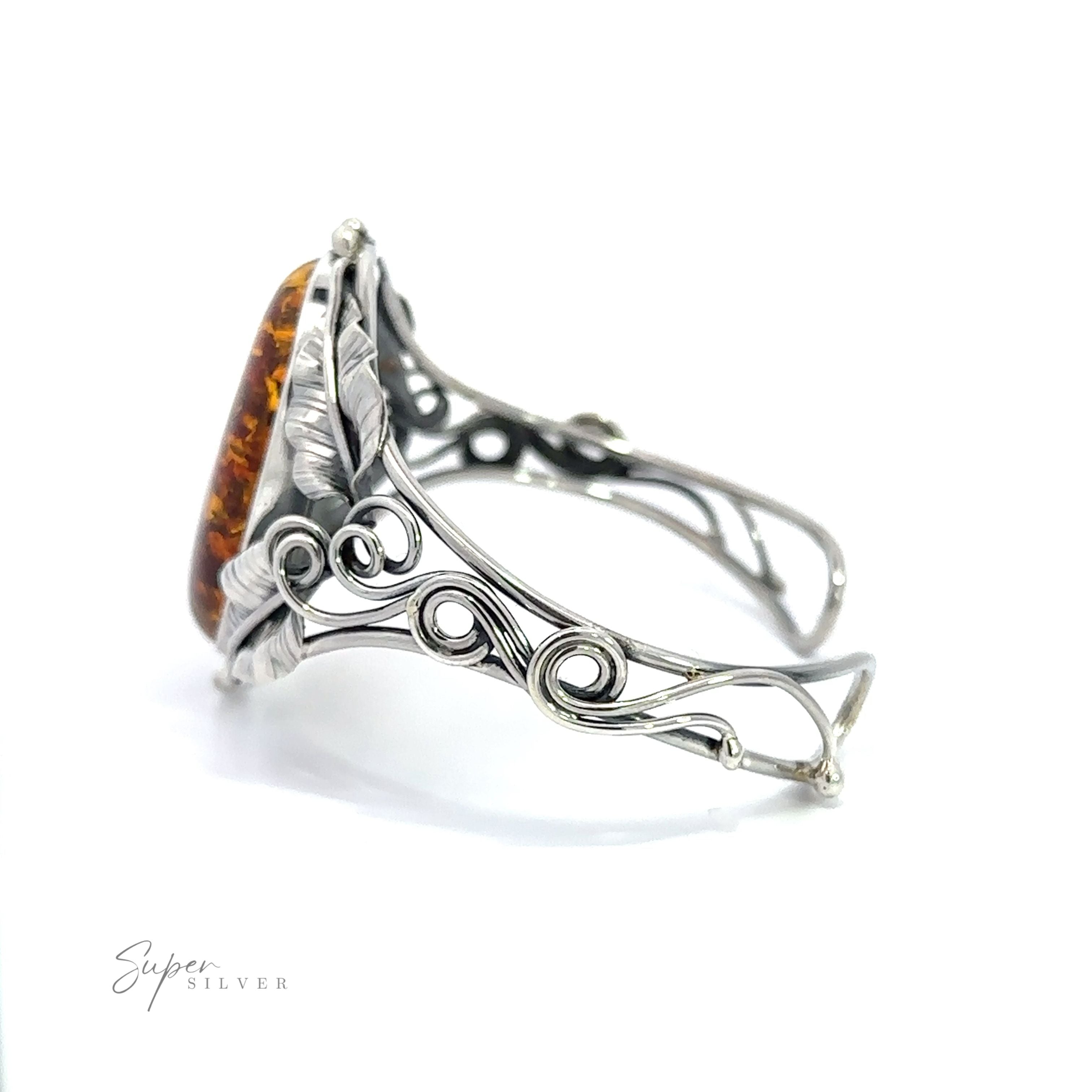 An Exquisite Amber Floral Cuff with an amber stone and a filigree design.