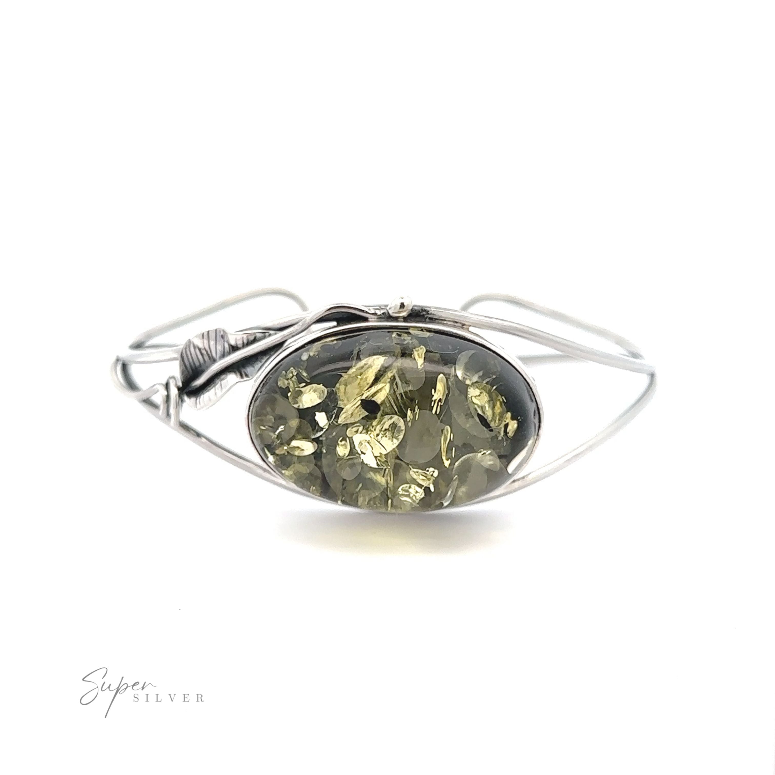 A Delicate Floral Amber Cuff with a green stone on it.
