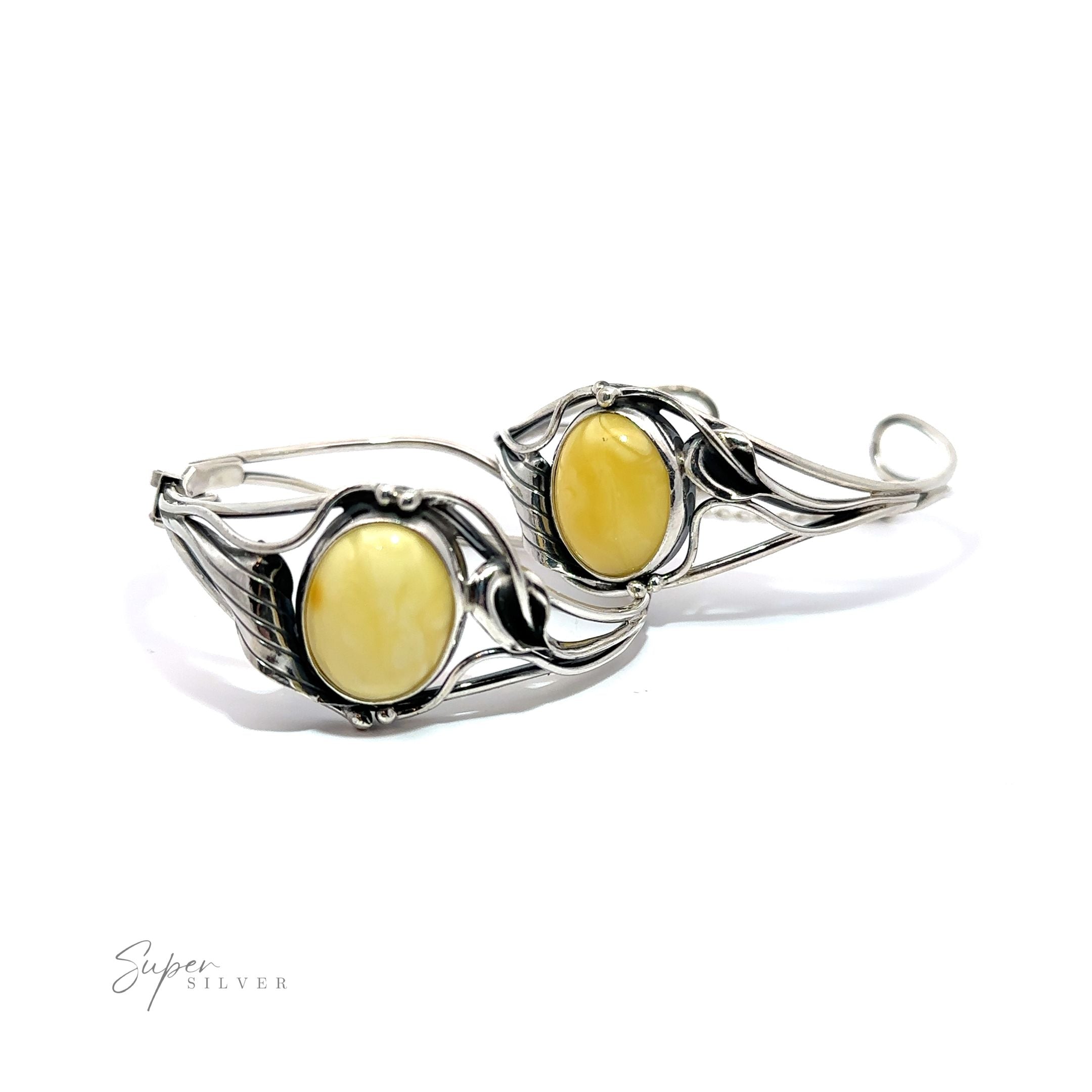 A pair of silver hoop earrings with vintage charm, adorned by yellow stones reminiscent of Butterscotch Amber Bracelet with Nature Detailing.