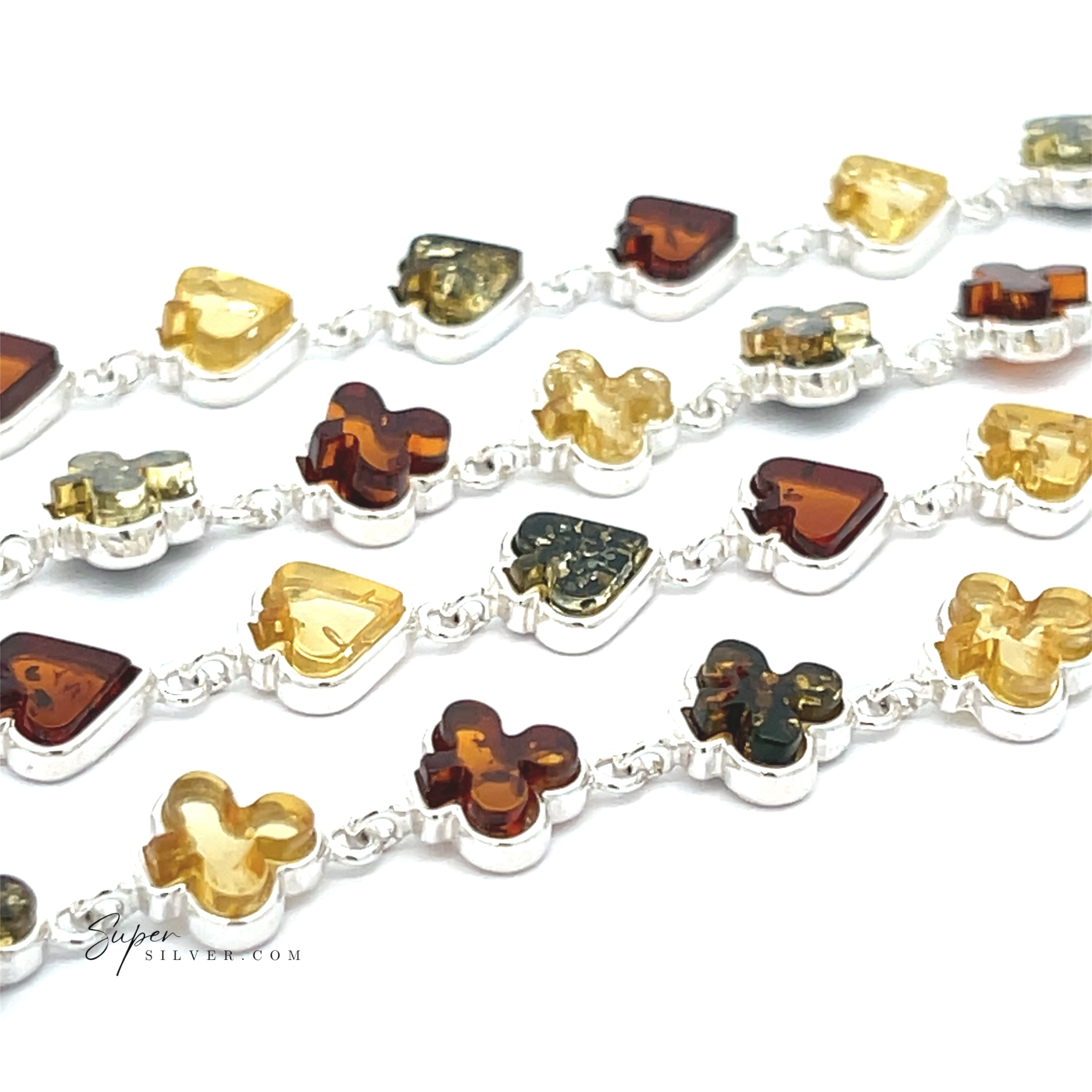 A close-up of Amber Card Suit Bracelets in sterling silver, adorned with heart, triangle, and clover charms, each set with genuine Baltic amber gemstones in honey, yellow, and brown hues.