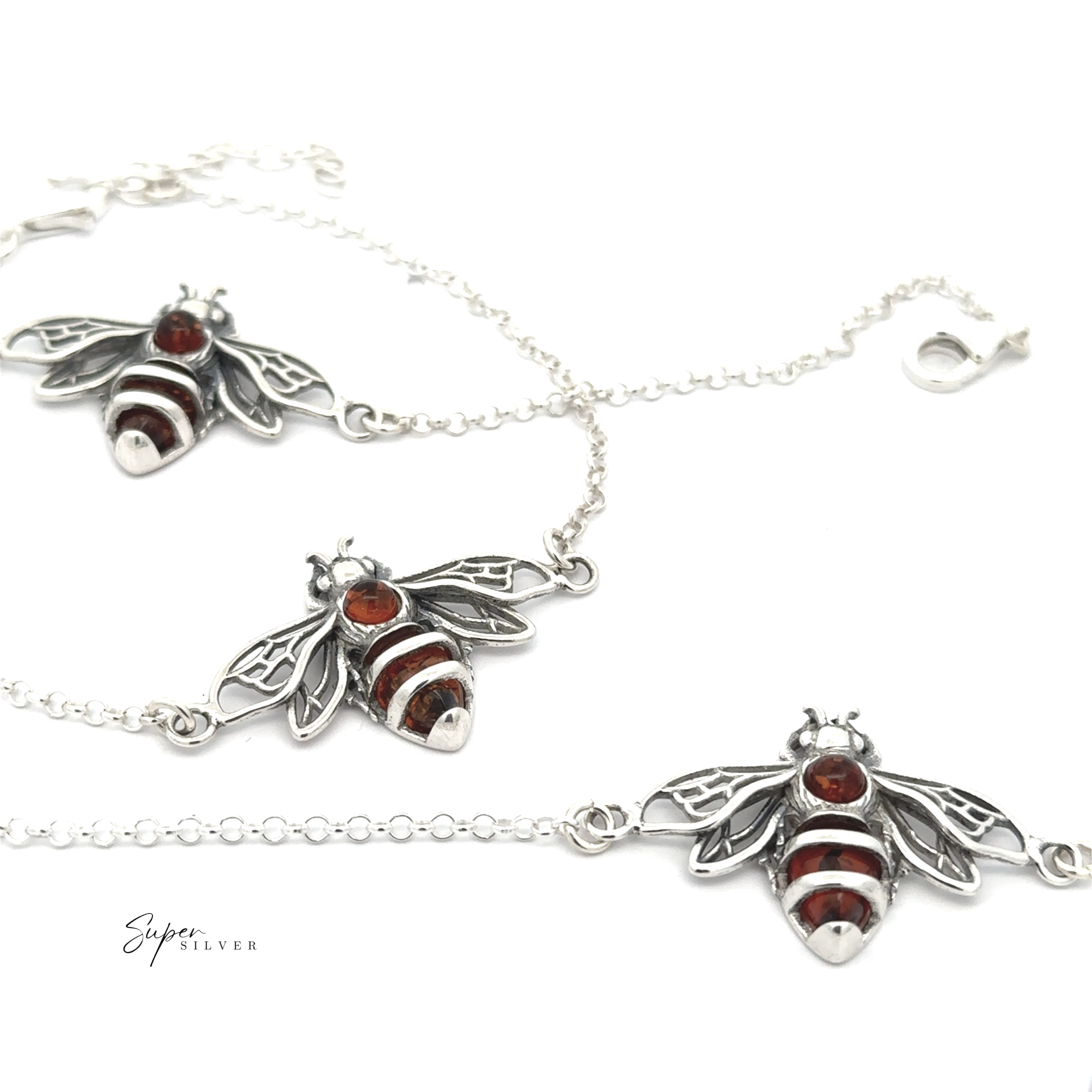 A Baltic Amber Honeybee Bracelet with a bee-shaped pendant, crafted from sterling silver and detailed with white enamel, displayed on a white background.