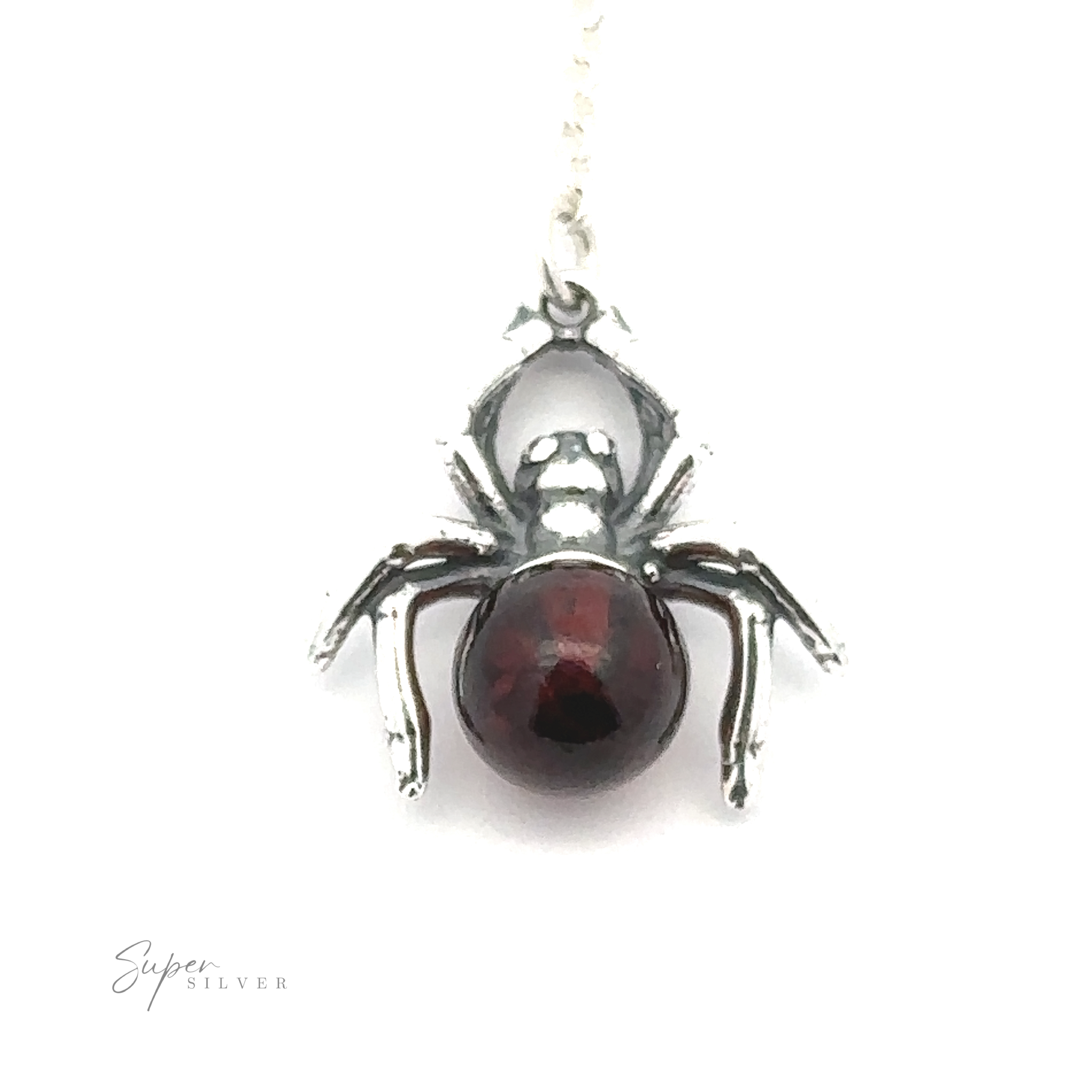 A Baltic Amber Spider Necklace with a dark, round Baltic amber gemstone on its back, hanging from a silver chain. "Super Silver" is inscribed in the bottom left corner, adding a witchy vibe to the piece.