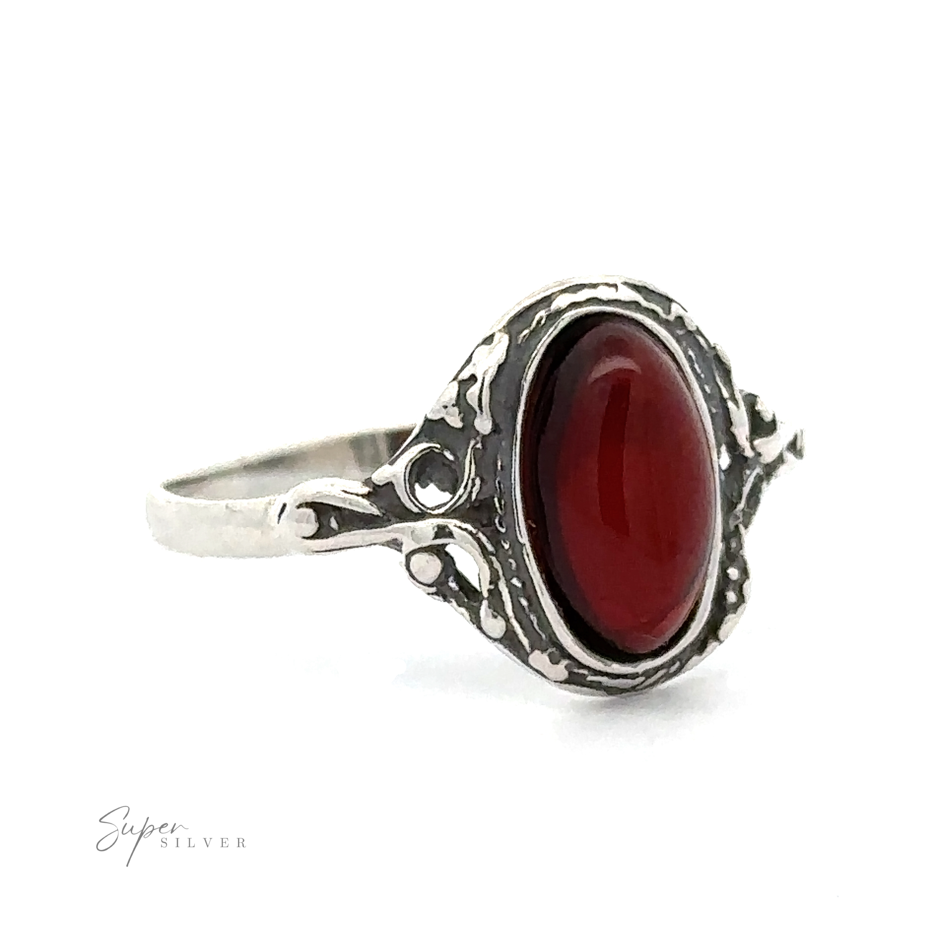 Delicate Baltic Amber ring featuring an oval cognac amber gemstone set in an intricate filigree band, displayed against a white background.