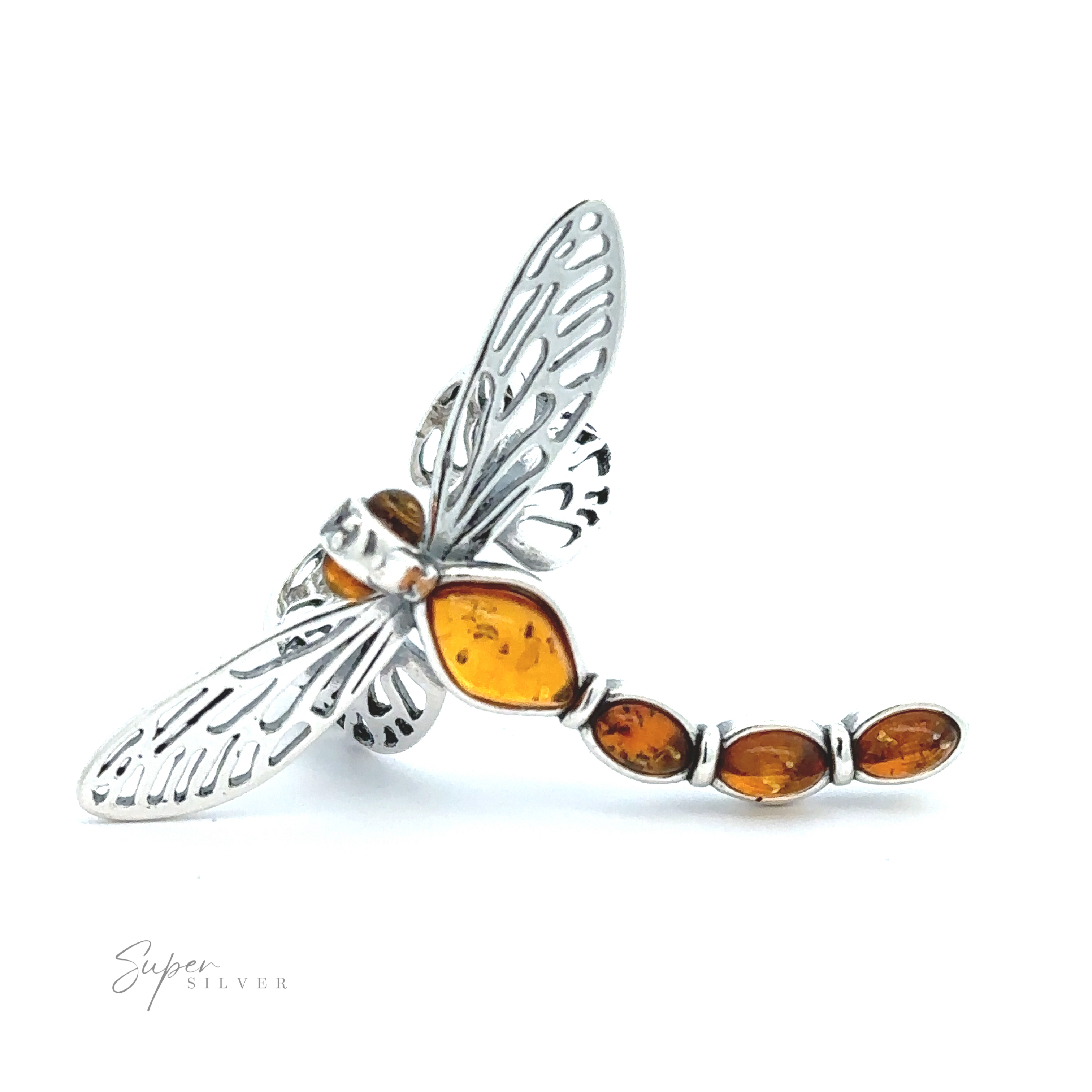 A silver dragonfly brooch featuring detailed wings and an amber gemstone body, this exquisite piece showcases nature-inspired jewelry. The Amber Dragonfly Adjustable Ring gleams beautifully against a plain white background.