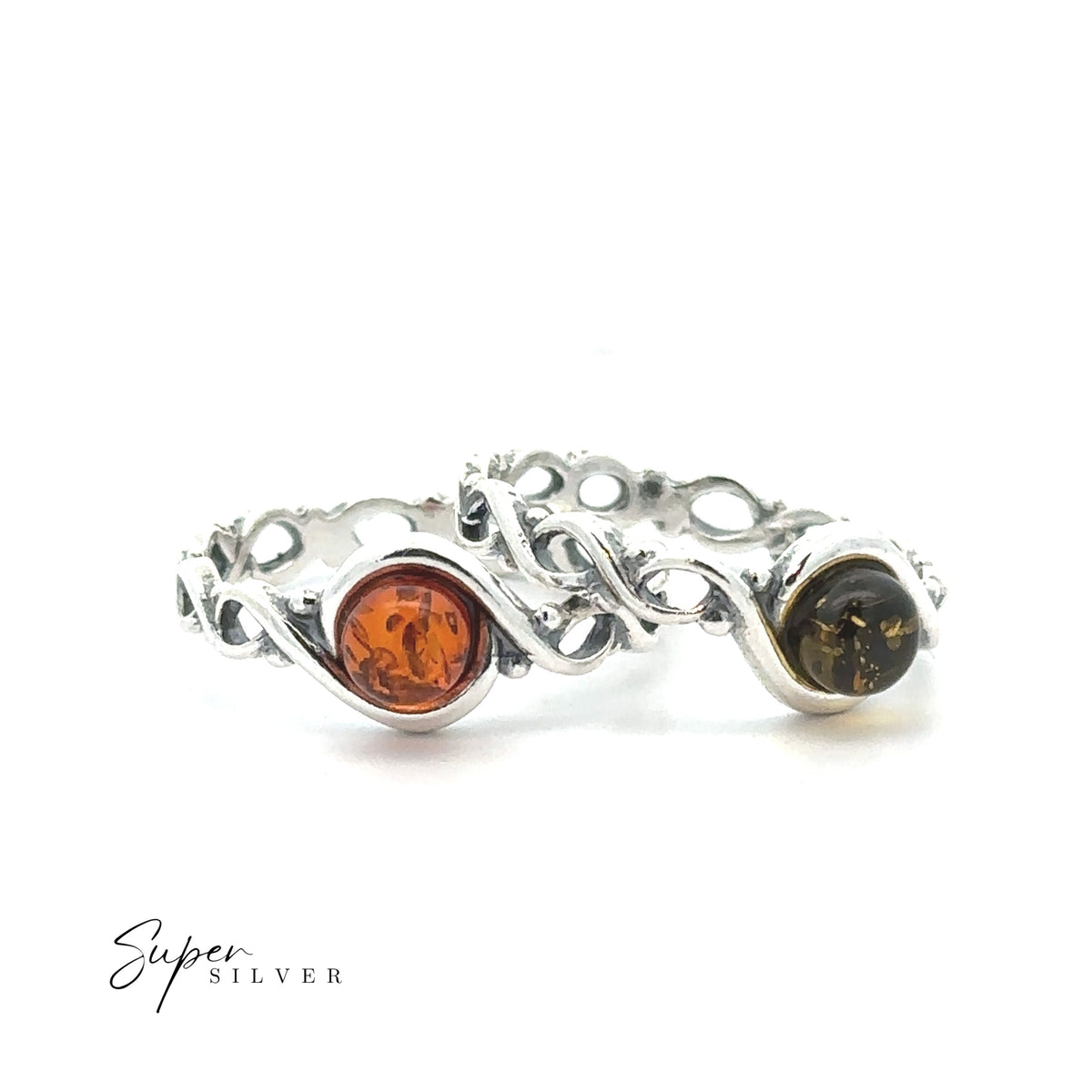 Two Baltic Amber Rings with Twisting Bands—one featuring a warm cognac round amber stone and the other set with a deep dark green round amber—are displayed on a white background.