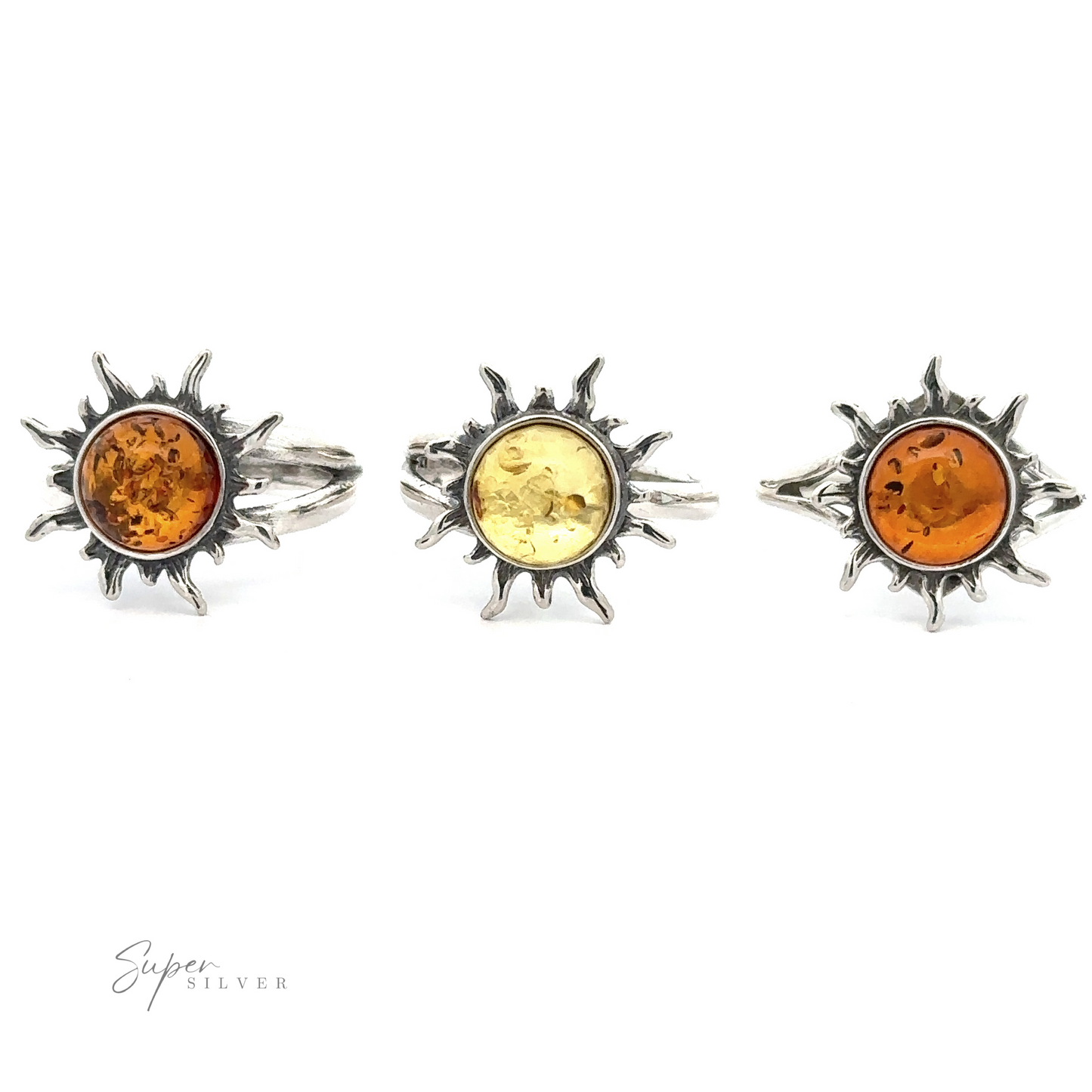 Three Glowing Amber Sun Rings with Baltic amber centers in various shades displayed against a white background.