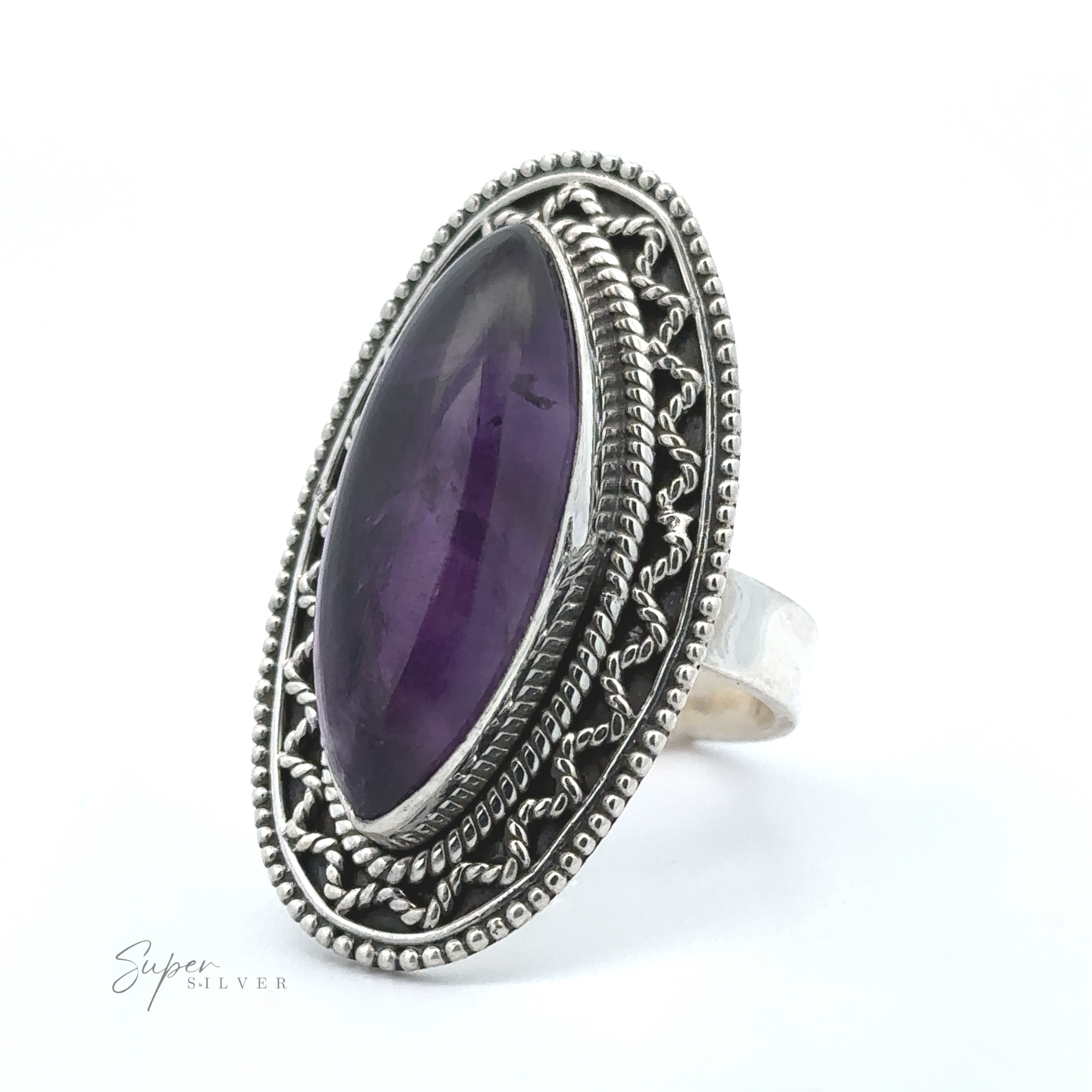 A Marquise Shaped Gemstone Ring With Vintage Shield Border featuring a large marquise-shaped purple gemstone set in an ornate bezel design, offering a bohemian twist with vintage appeal.