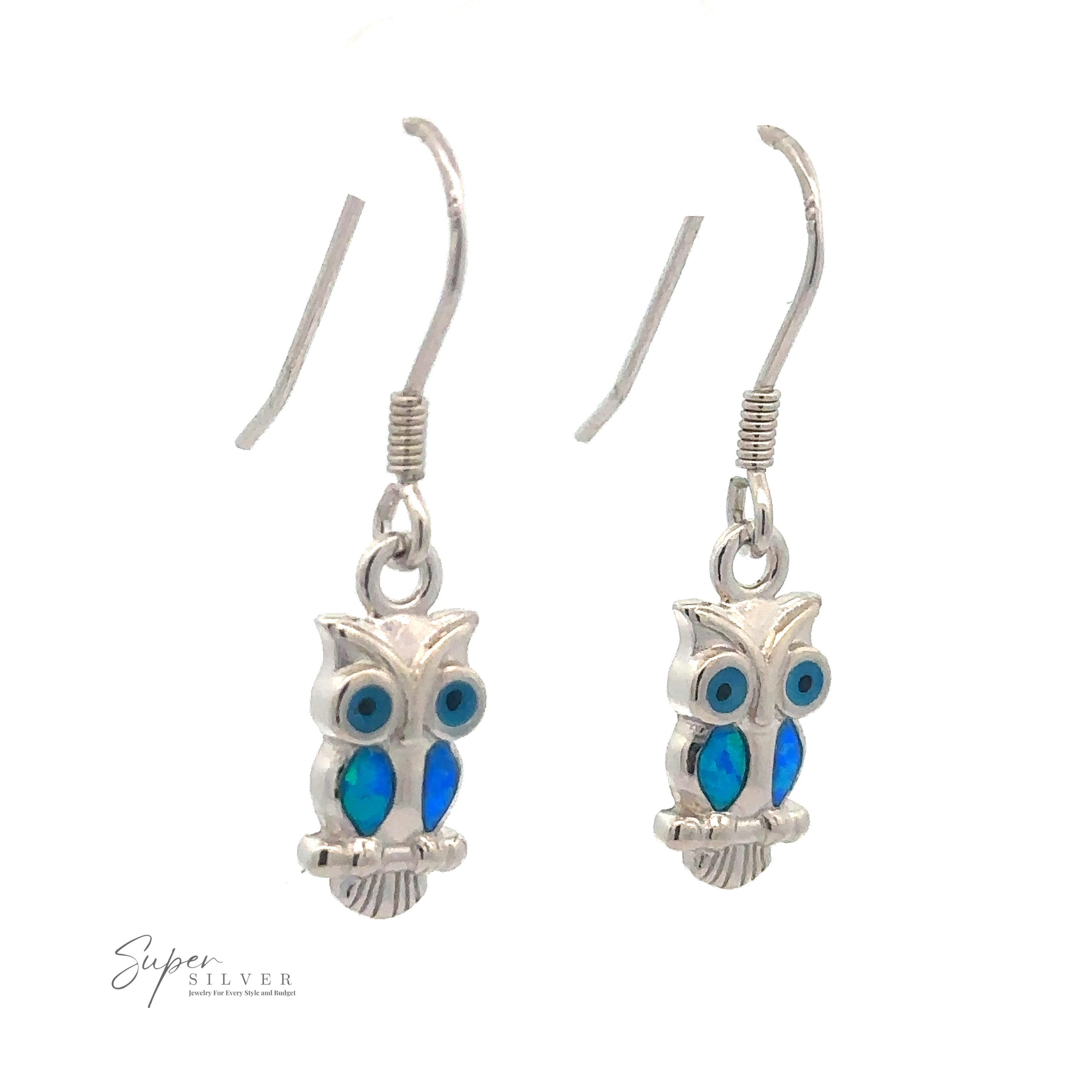 A pair of Lab-Created Opal Owl Earrings with blue accents hanging from hooks. The logo "Super Silver" is visible in the bottom left corner, showcasing this creative jewelry piece.