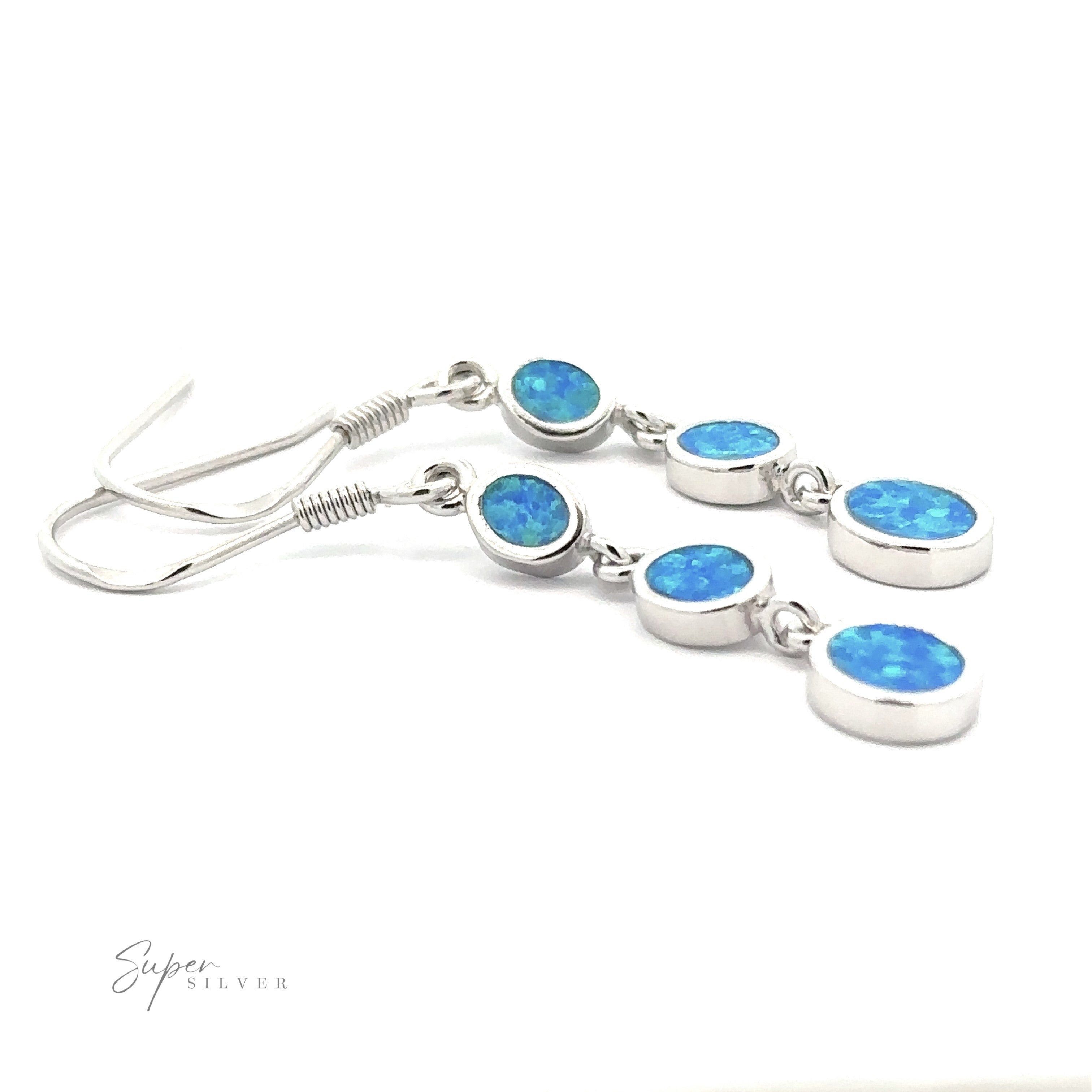 Introducing the Long Oval Blue Lab-Created Opal Earrings, a stunning pair of Sterling Silver drop earrings adorned with three small, oval-shaped blue lab-created opal stones on each earring, enhanced with a subtle geometric design.