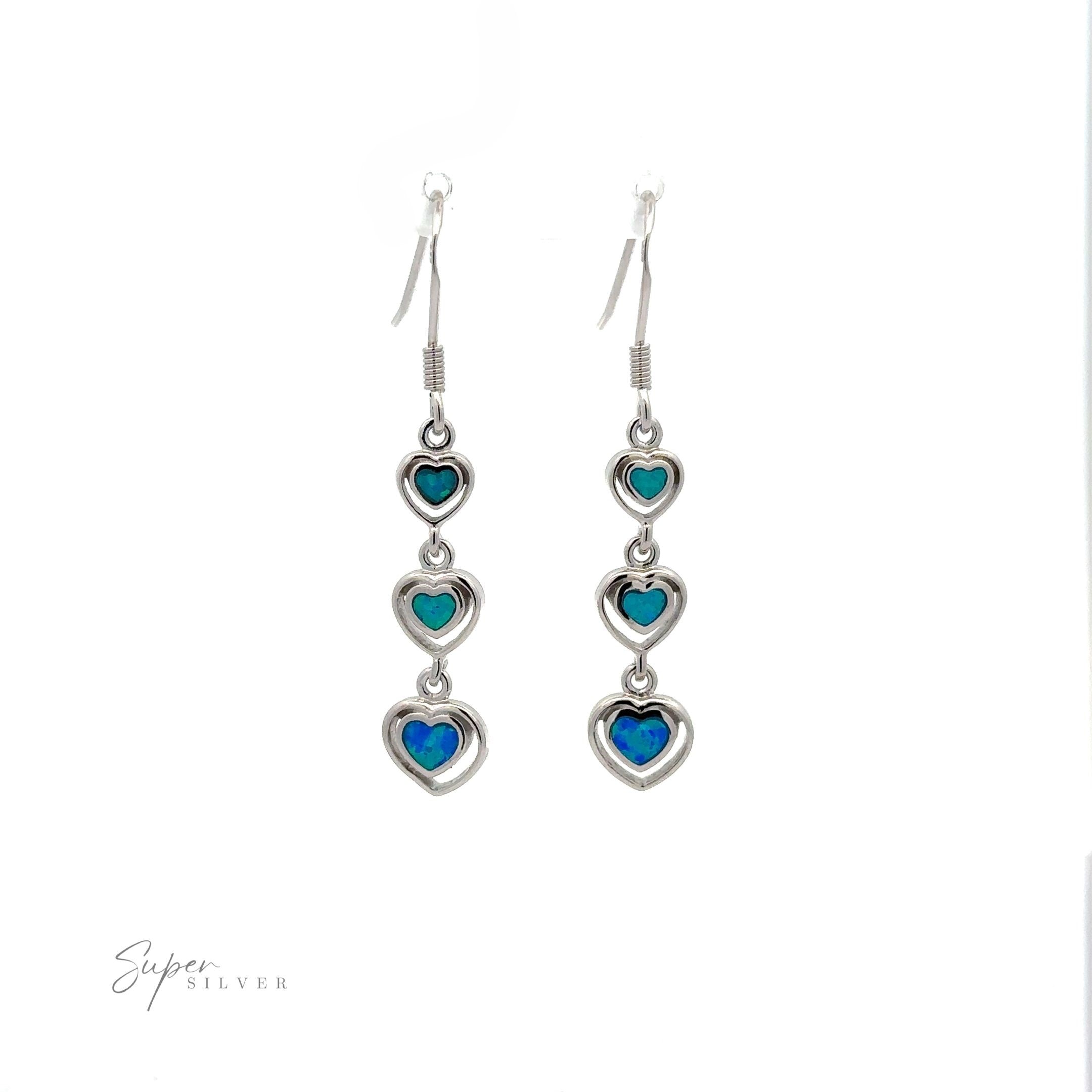 A pair of Dangling Lab-Created Opal Heart Earrings featuring three small turquoise and lab-created blue heart-shaped opal stones in each earring, displayed on a white background.