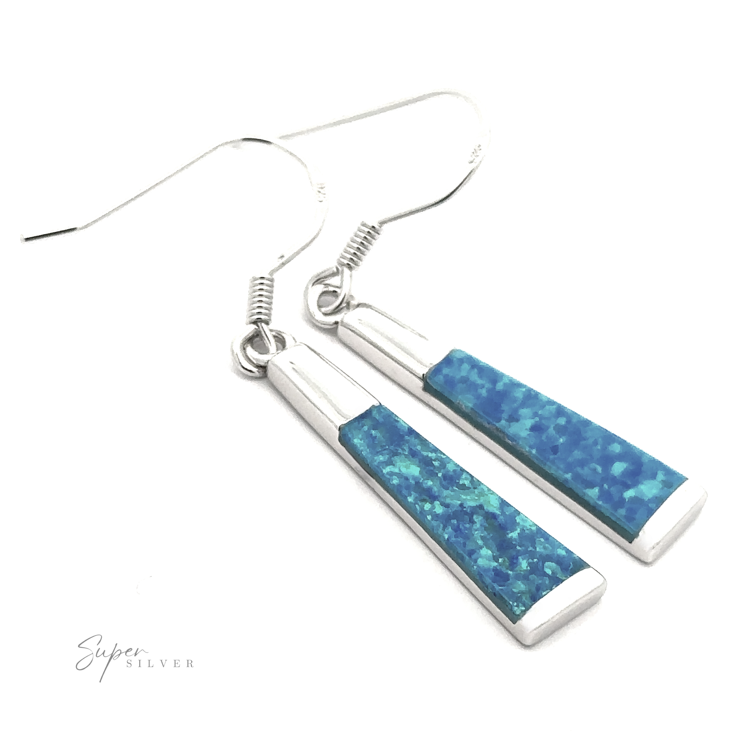 The Elegant Long Opal Earrings feature silver hooks and blue rectangular pendants with a textured, mosaic design that showcases varying shades of blue and green. This modern accessory is ideal for the contemporary artsy woman.