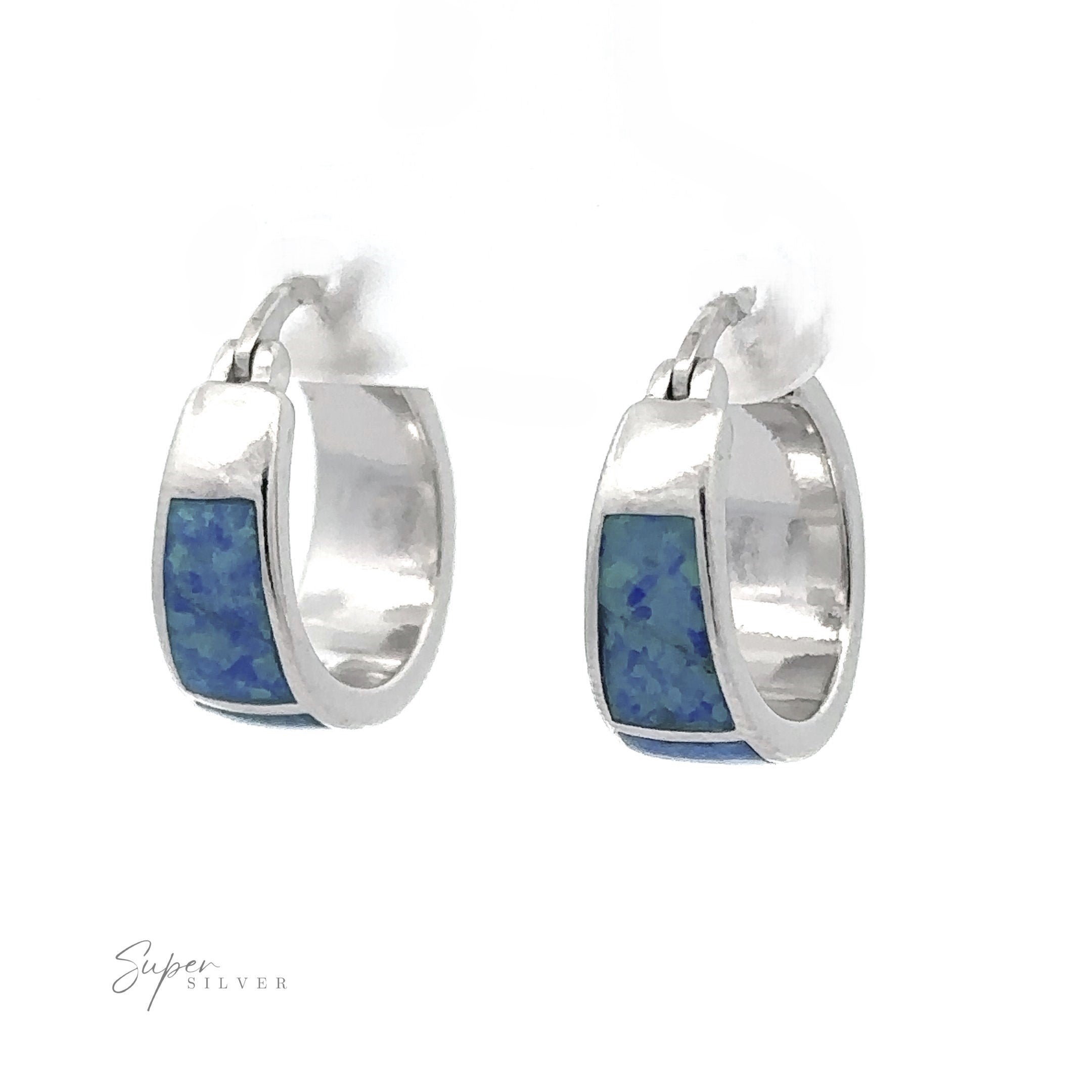 Blue Lab-Created Opal Huggie Hoop Earrings with silver design and vibrant blue lab-created opals set against a white background, finished with a stunning rhodium coating.