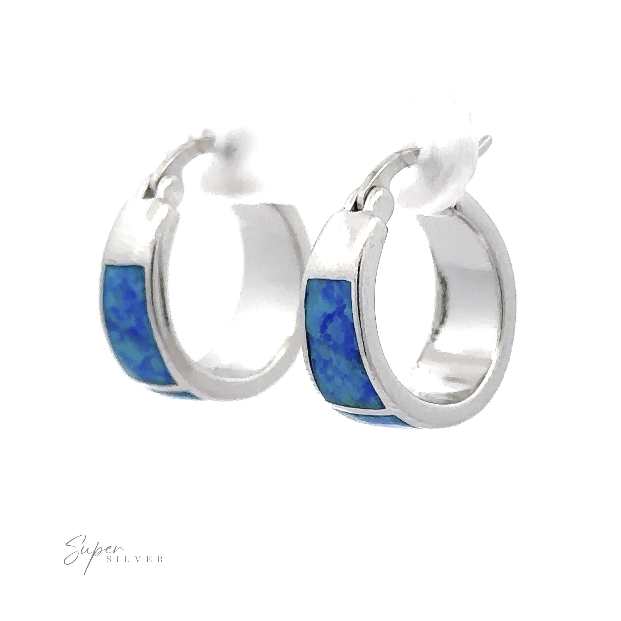 A pair of Blue Lab-Created Opal Huggie Hoop Earrings, showcasing silver hoops with a rhodium finish and blue lab-created opals set against a white background.