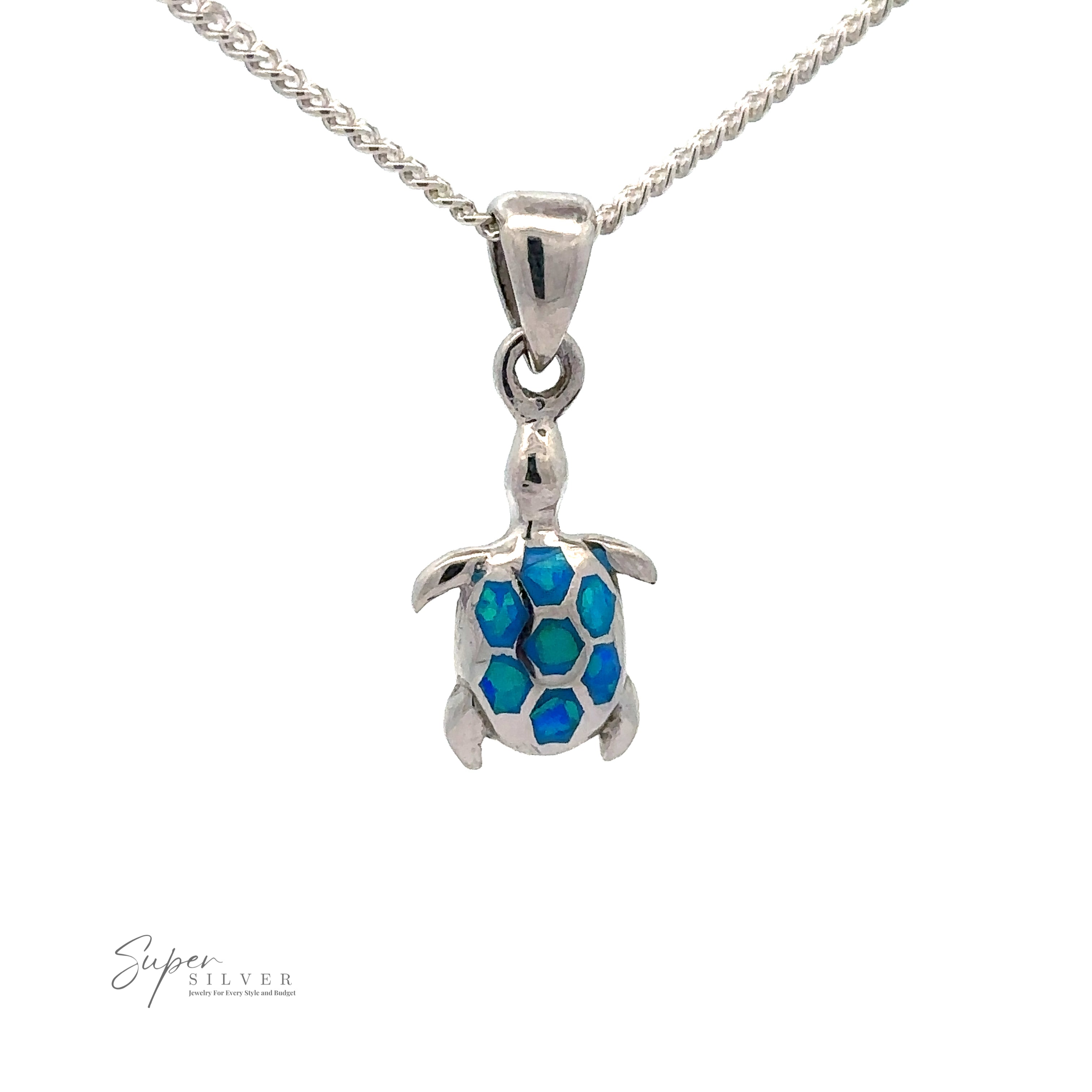 A Dainty Blue Opal Sea Turtle Pendant. The turtle shell features blue and green hexagonal patterns, evocative of marine life with striking blue opal stones. The chain is a twisted rope design, and the logo "Super Silver" is visible.