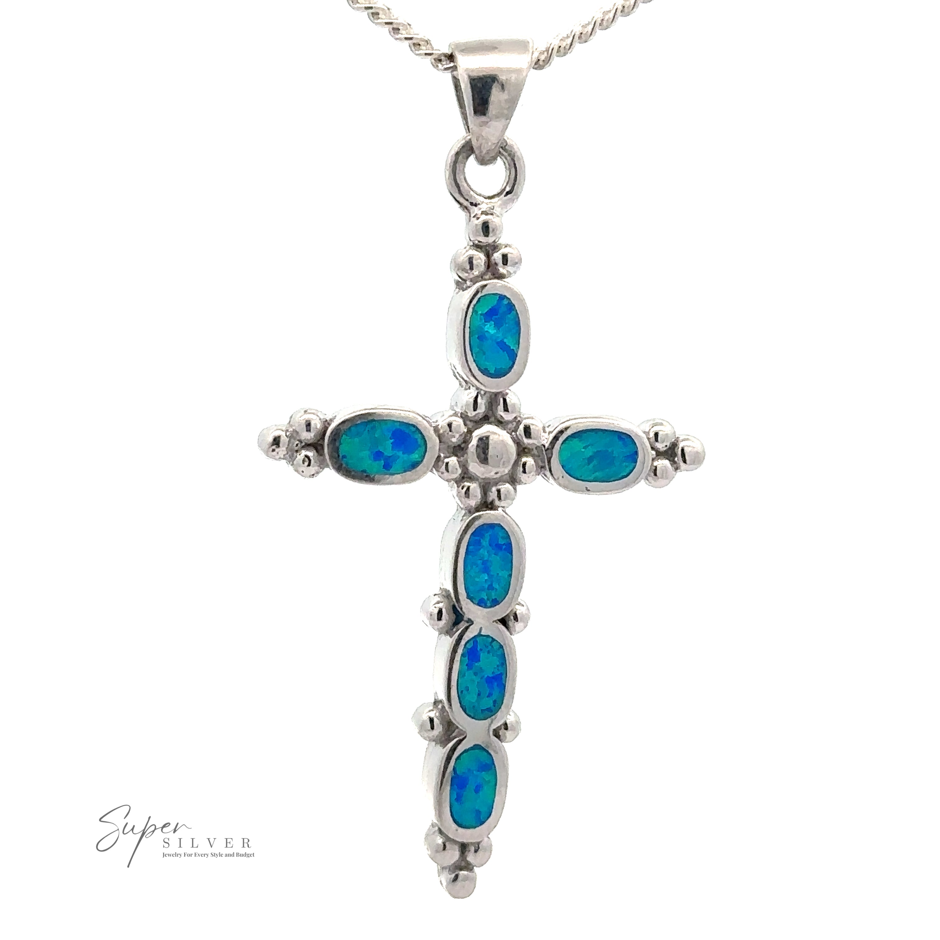 A Blue Opal Cross Pendant With Oval Stones featuring blue-green oval blue opal gemstones, hanging on a silver chain. The image includes a "Super Silver" logo in the bottom left corner.