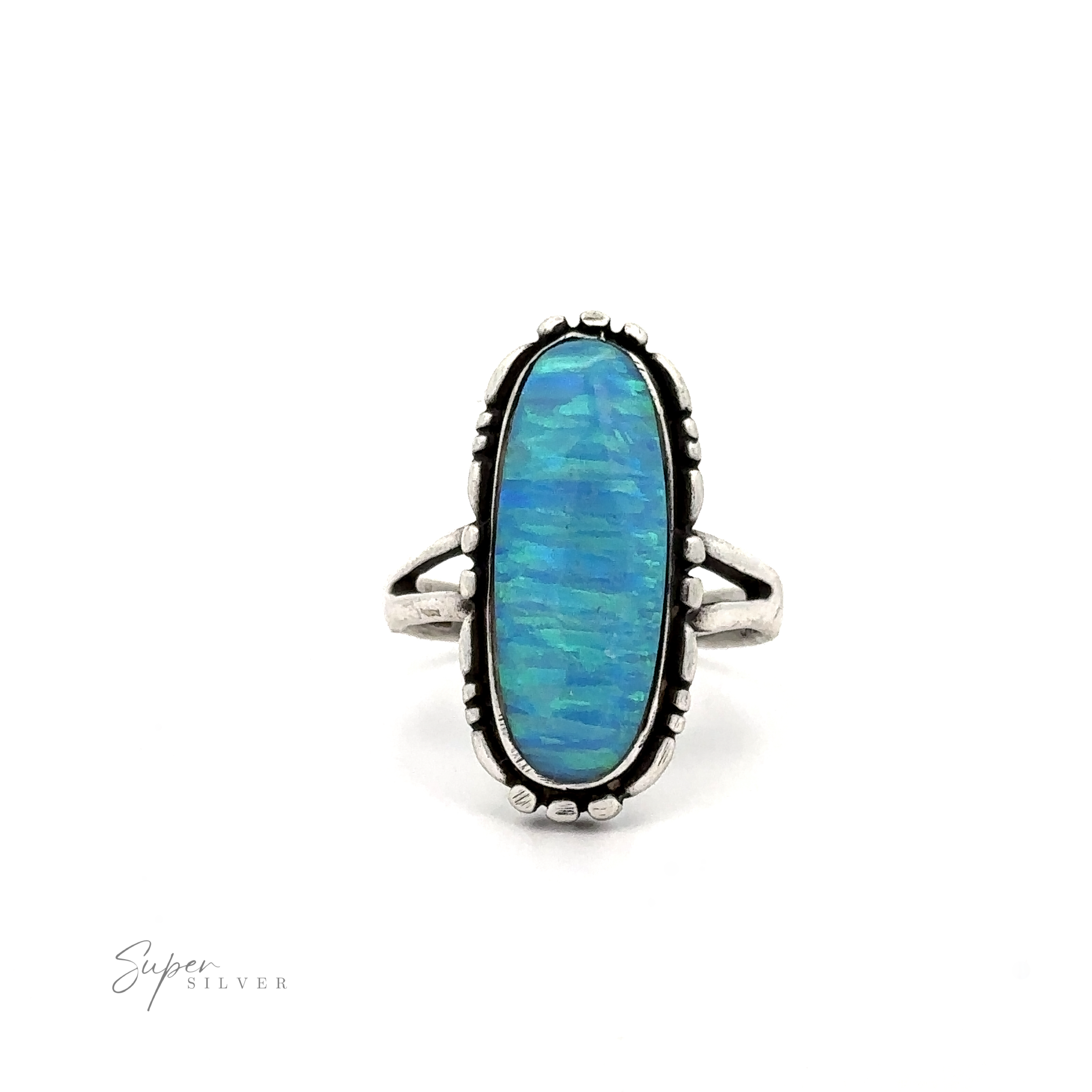 A sterling silver ring with an oval-shaped, lab-created blue opal stone featuring an iridescent pattern. The Southwestern-styled band and setting add intricate detail. The brand logo "American Made Oval Opal Ring" is seen in the bottom-left corner.