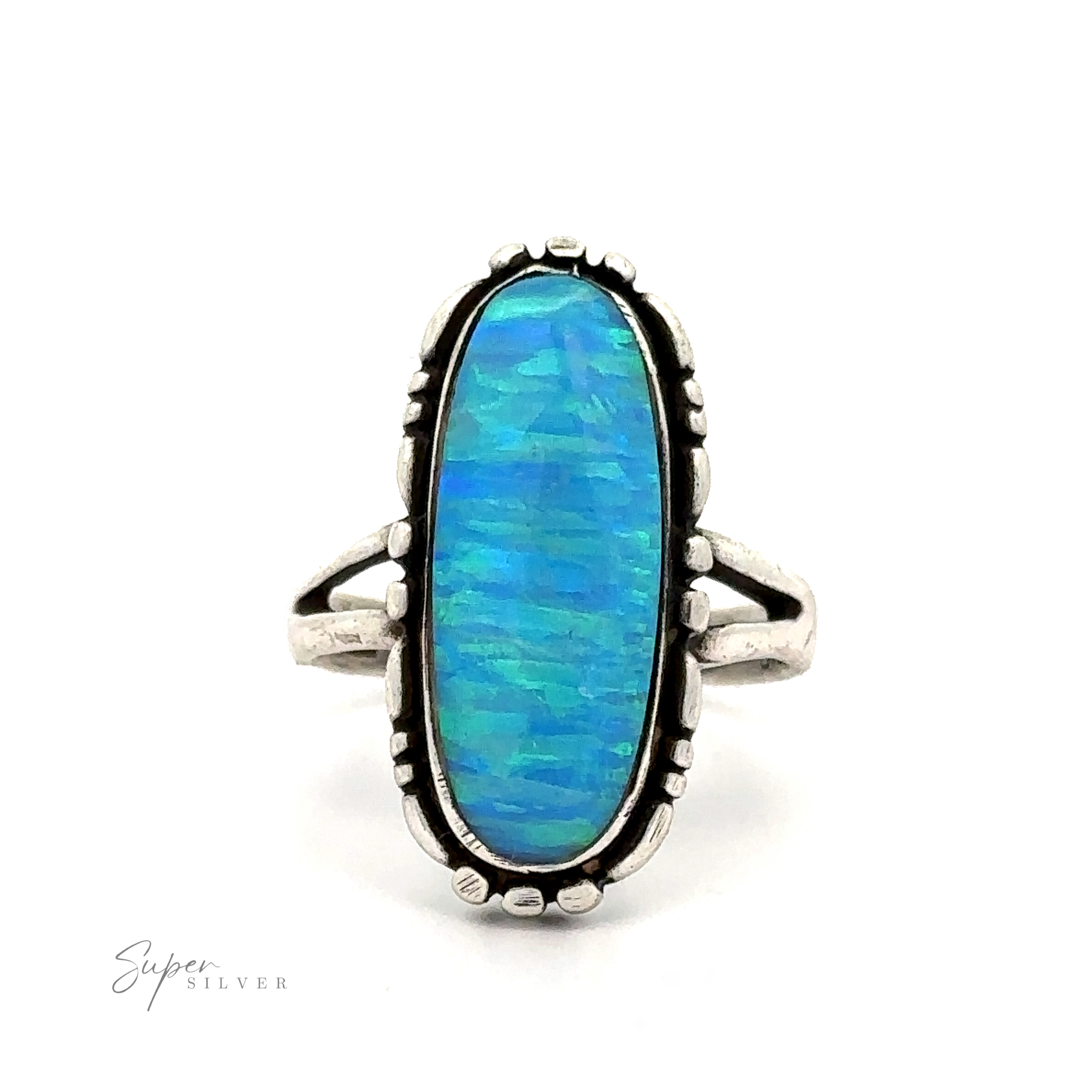 A sterling silver ring with an oval-shaped lab-created blue opal gemstone set in an ornate bezel setting, featuring intricate Southwestern-styled details on the band. The text "American Made Oval Opal Ring" is in the corner.