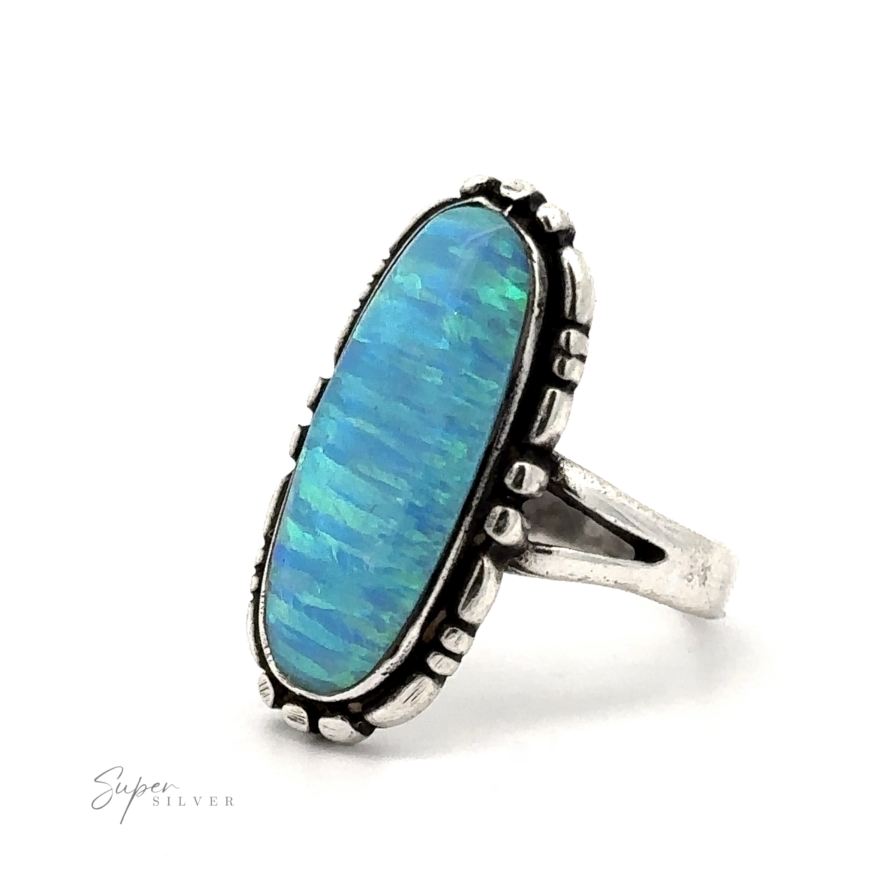 An American Made Oval Opal Ring with a Southwestern-styled sterling silver design features an elongated, oval-shaped lab created blue opal gemstone. The band has a split shank design. The background is white.