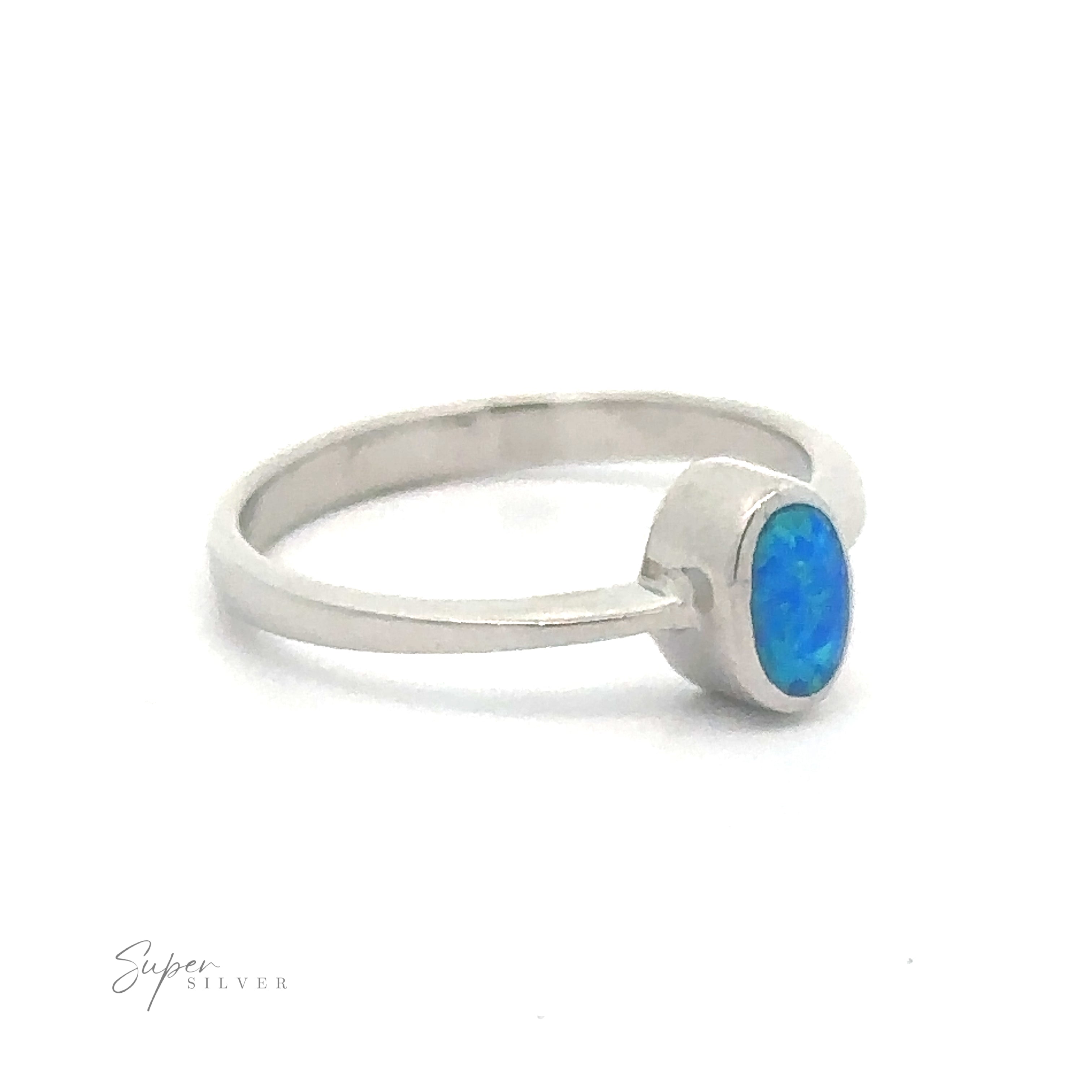 Rectangular Lab Opal ring, rhodium plated, with a round blue Opal set in a bezel setting.