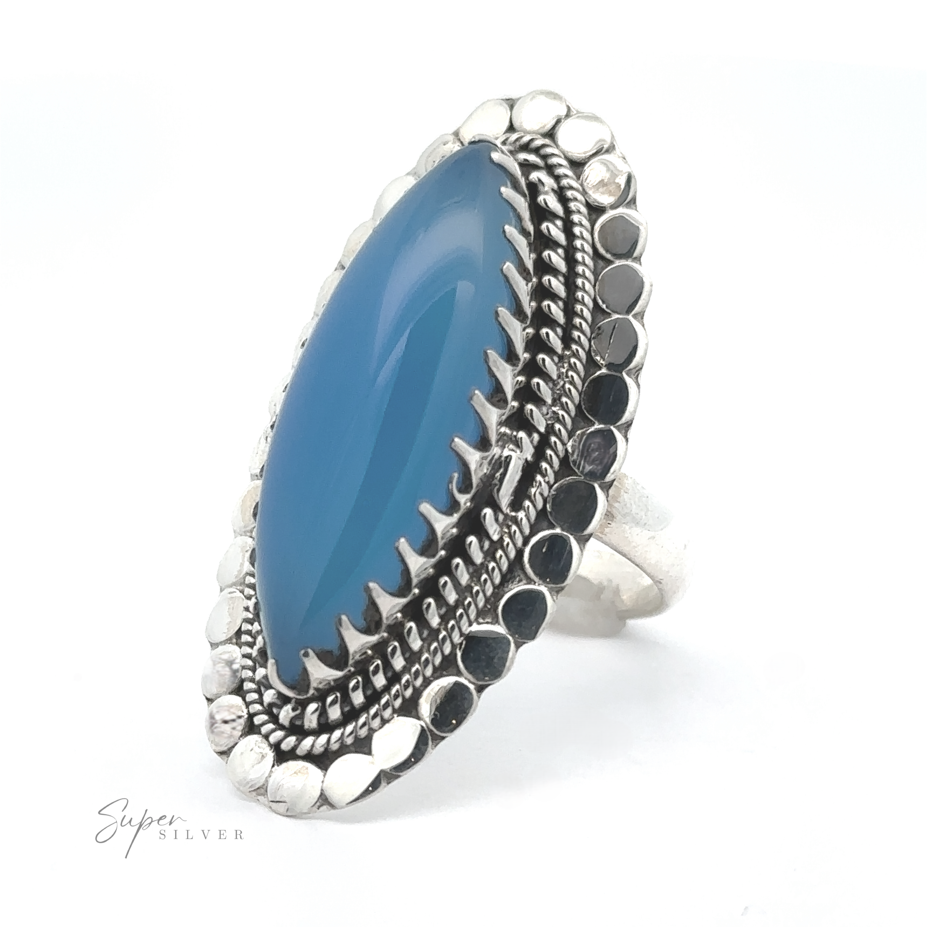 A silver ring featuring a large, oval-shaped blue gemstone, surrounded by intricate metallic detailing, this Statement Marquise Shaped Gemstone Ring captures attention effortlessly.