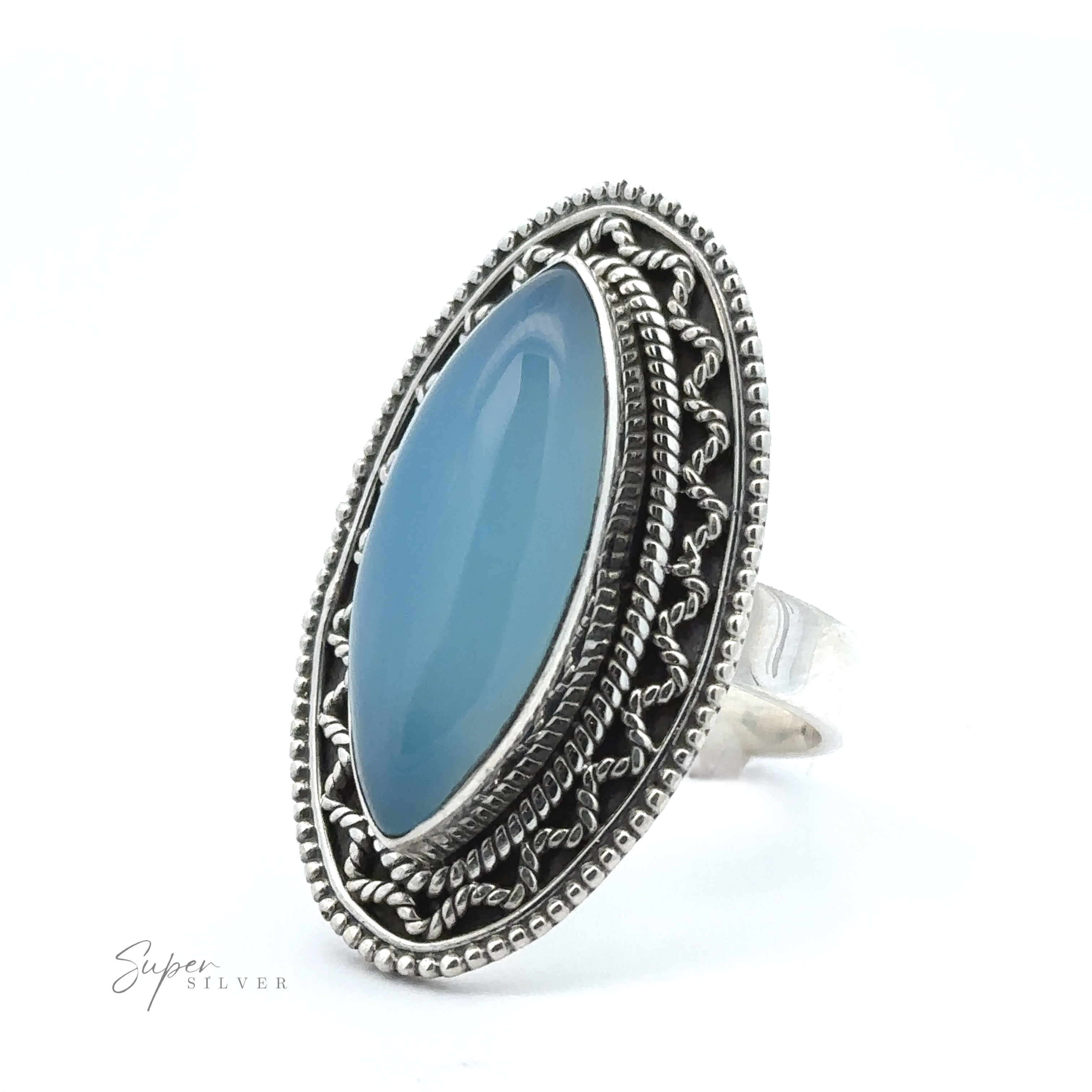 A stunning Marquise Shaped Gemstone Ring With Vintage Shield Border with intricate designs featuring a large marquise-shaped, oval blue gemstone set in the center. The ring is displayed against a white background, adding a Bohemian twist to its timeless elegance.
