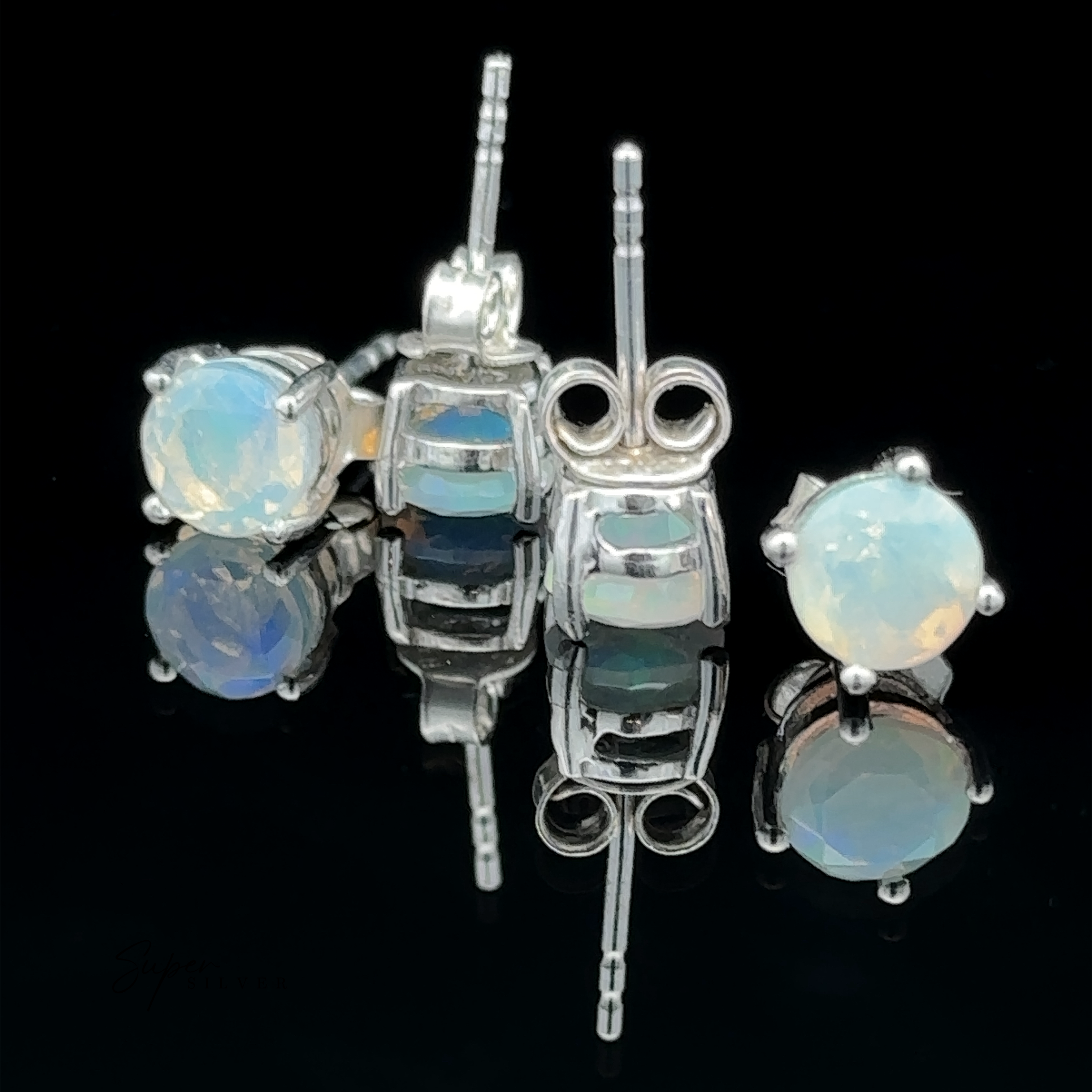 Round Ethiopian Opal Studs, each featuring a 6mm opal set in sterling silver, are displayed on a glossy black surface with reflections visible.