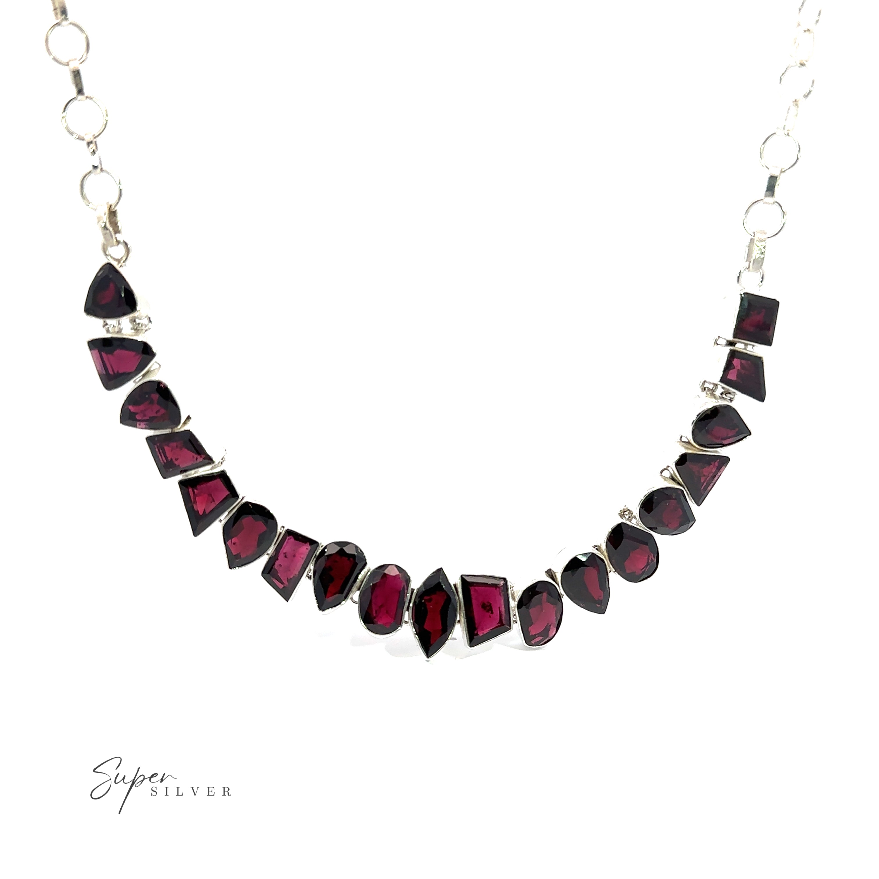 Statement Gemstone Necklace with alternating garnet and red gemstones in various shapes, featuring a chain with circular links. "Super Silver" text is visible in the bottom left corner.