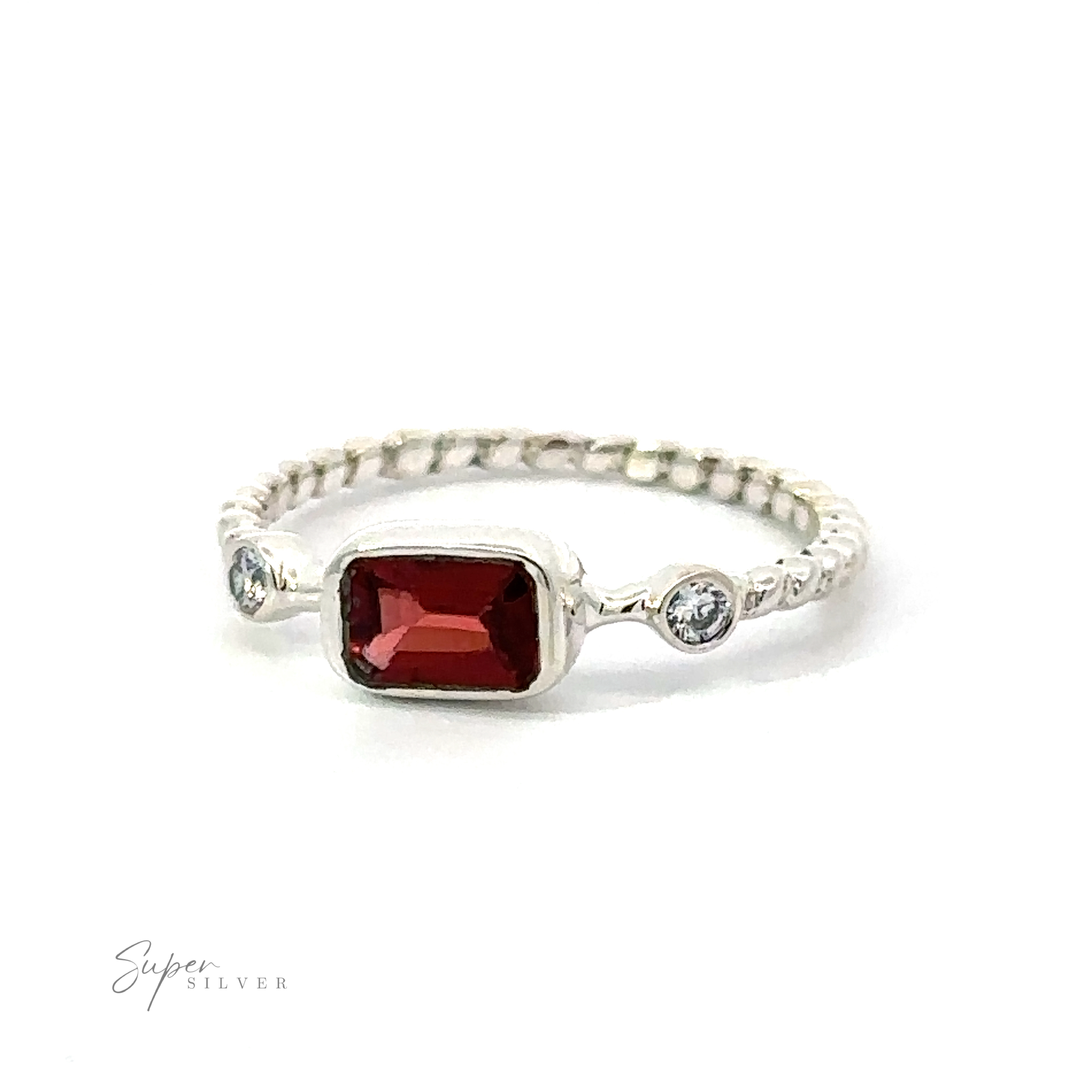 Rectangle gemstone ring with twisted band featuring a central red gemstone flanked by two smaller clear gemstones, exuding sparkling sophistication, displayed on a white background.