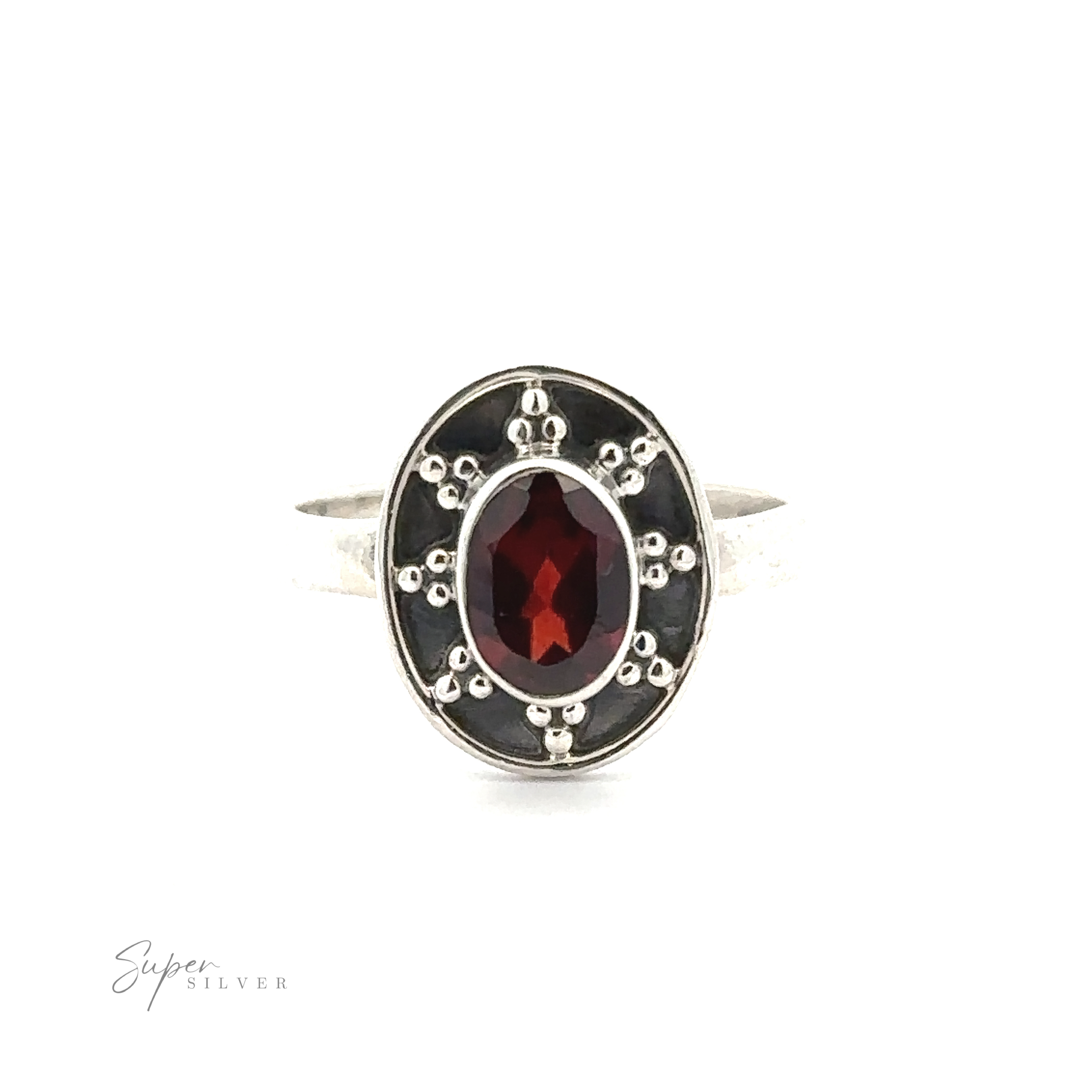 An Oval Gemstone Ring with Ball and Disk Border features an oval red gemstone encased in a decorative bezel setting with dotted detailing around it. The ring has a minimalist design with a "Super Silver" logo in the corner, exuding the charm of vintage-inspired jewelry.